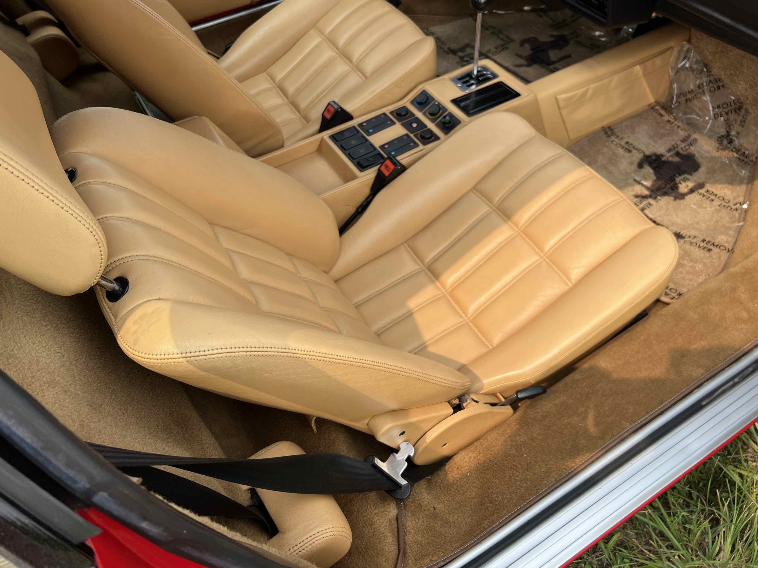 Interior of a car showing tan leather seats and center console with controls.
