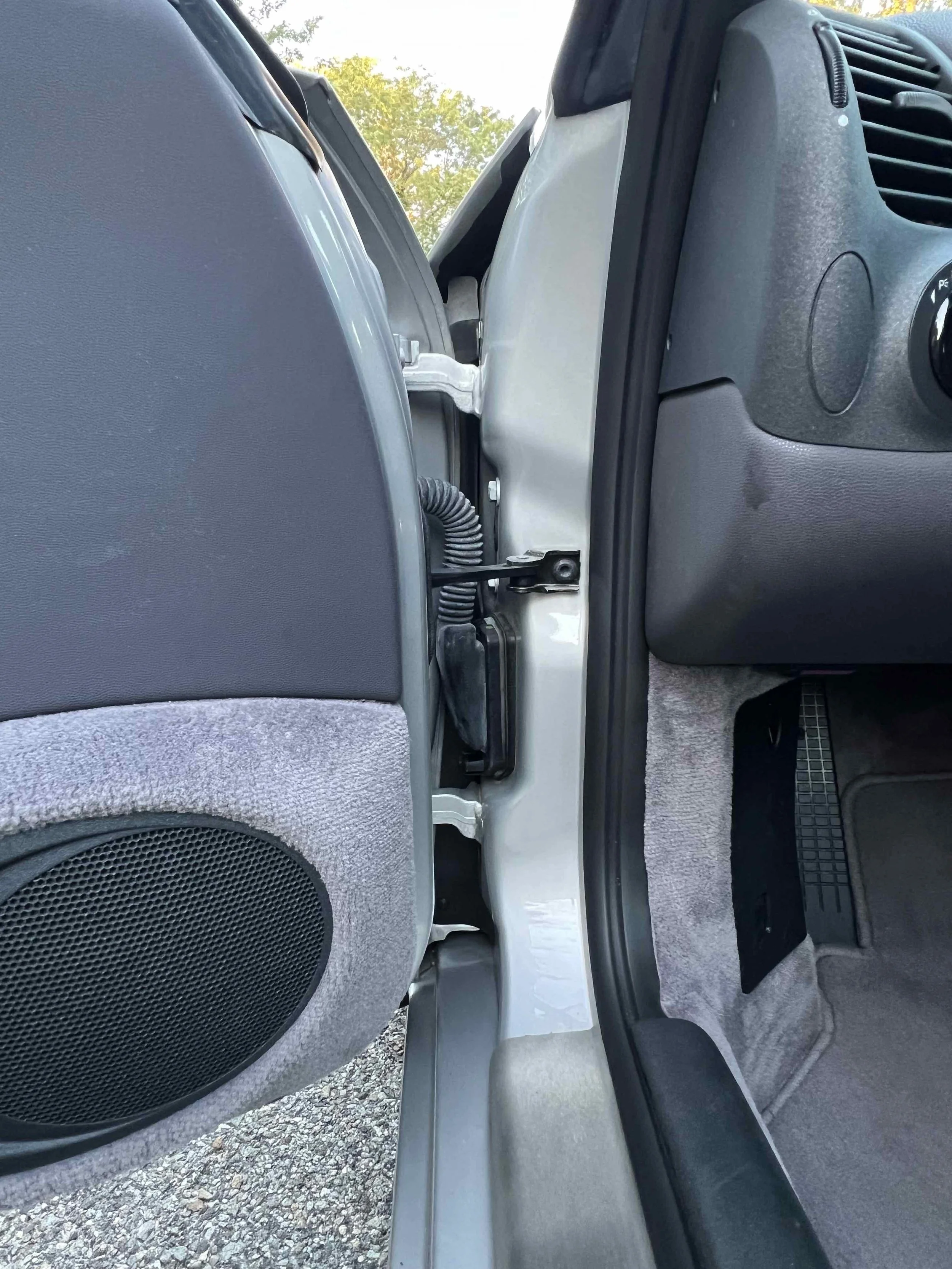 Interior of a car door jamb showing door latch and wiring.