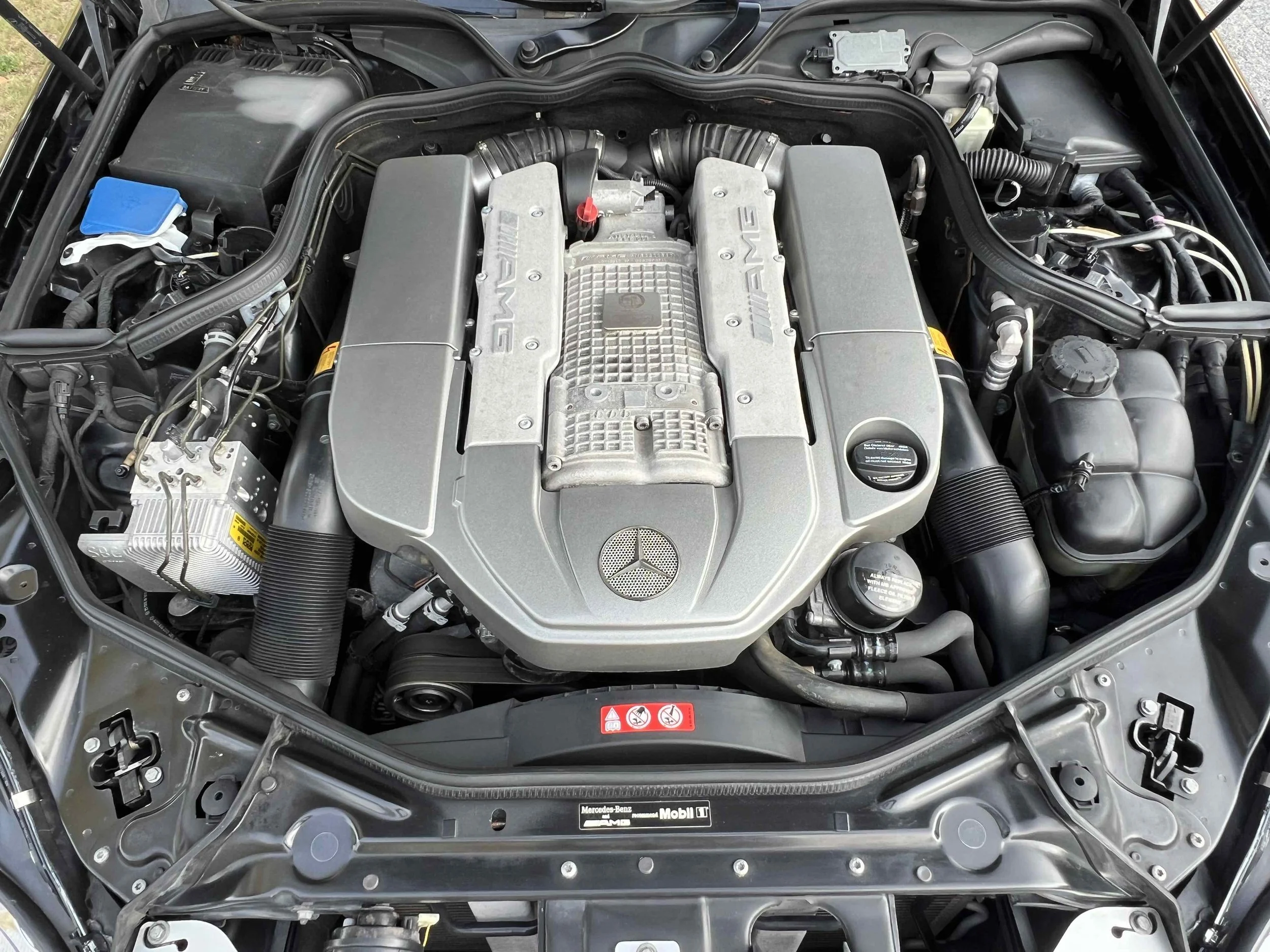 Close-up of a Mercedes-Benz AMG engine in a car's open hood.