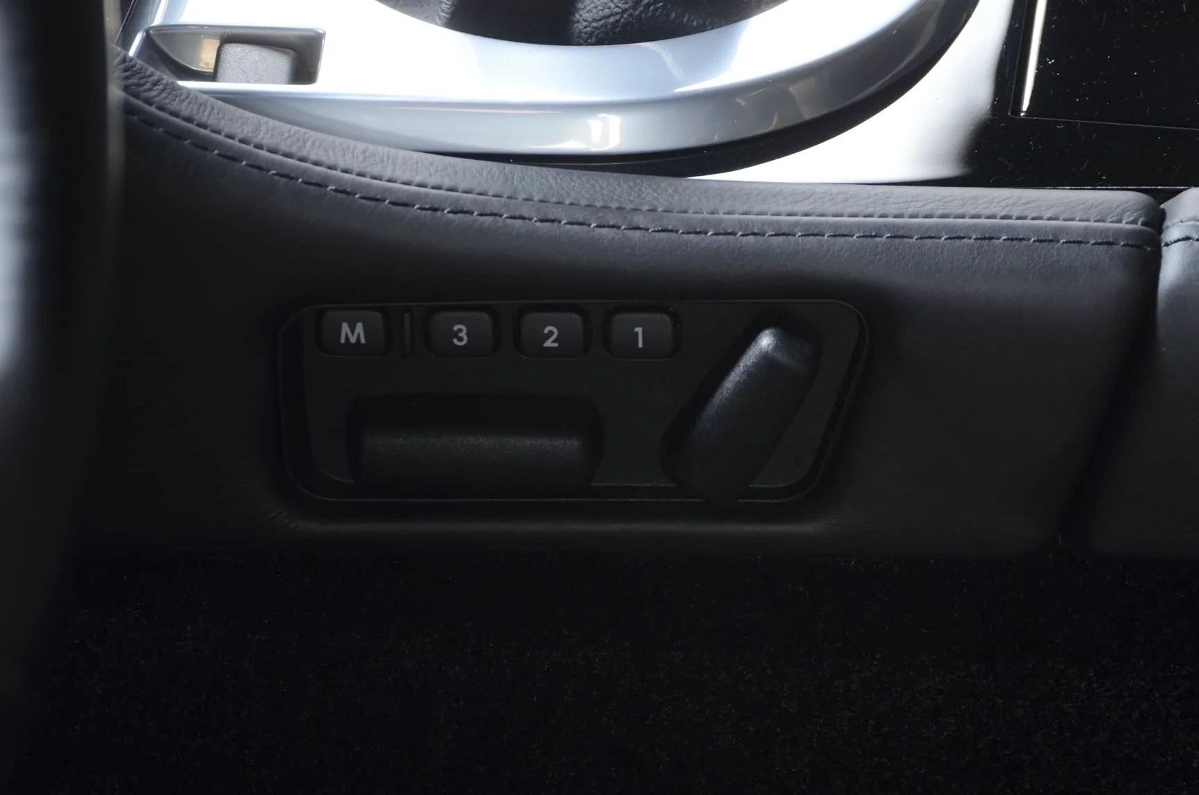 Car seat with memory settings buttons labeled M, 1, 2, 3.