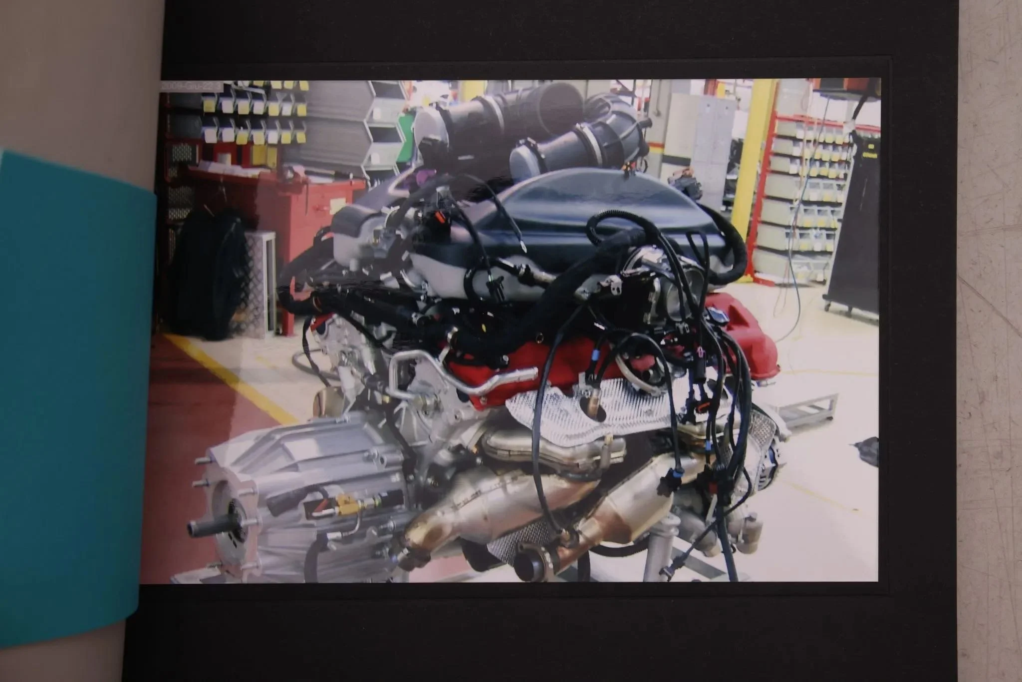A partially assembled car engine on a workbench in a workshop environment.