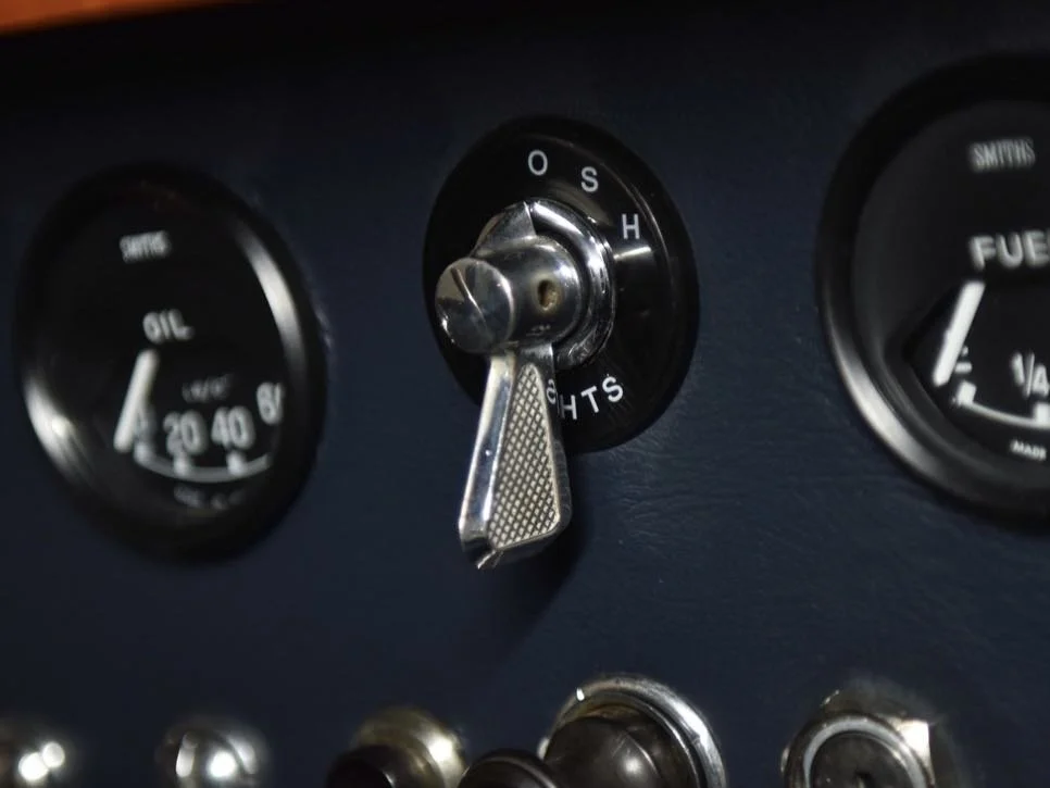 Dashboard of a vehicle showing a switch labeled 'Lights' with position options Off, S, and H, and additional gauges for oil pressure and fuel level.