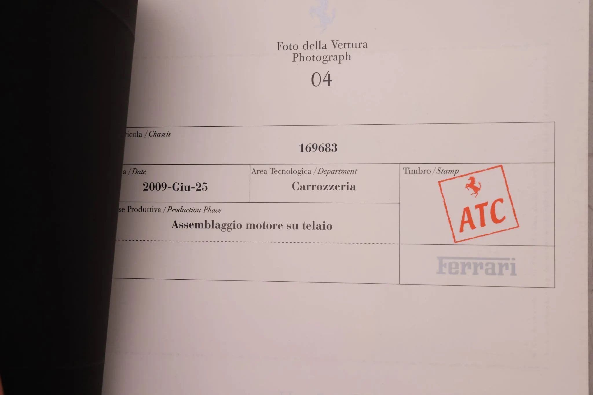 A document page with a stamp marked 'ATC' featuring a prancing horse logo, and the word 'Ferrari' faintly visible in the background, indicating an association with the Ferrari brand.