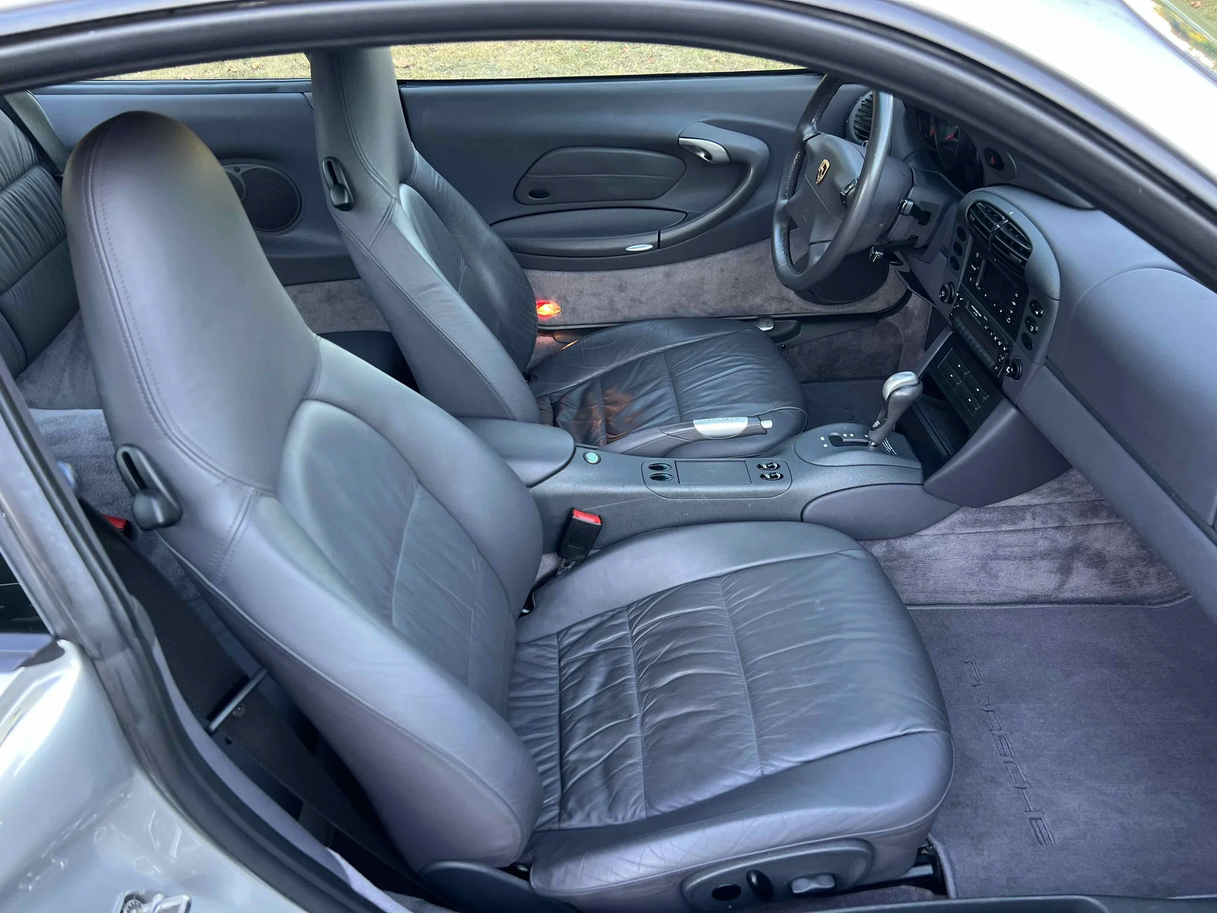 Interior of a car showing front leather seats, dashboard, and gear shift.