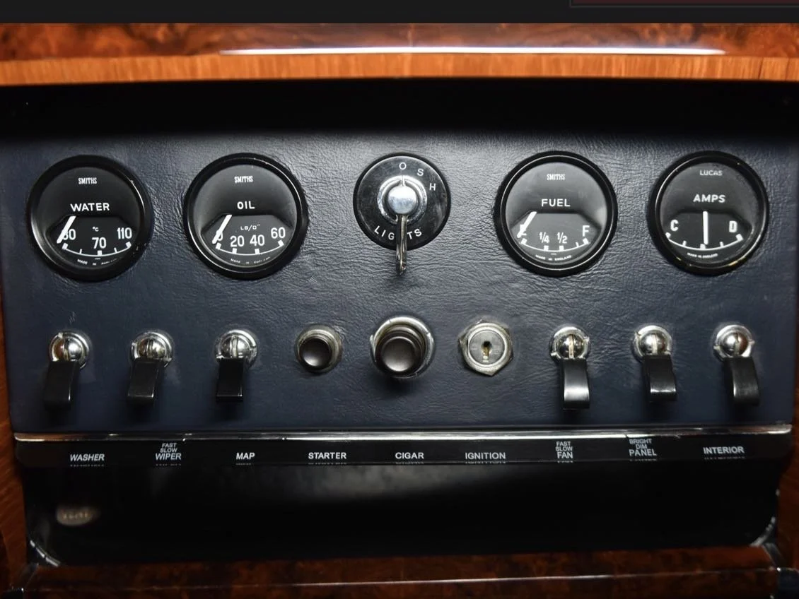 Dashboard with gauges for water temperature, oil pressure, fuel level, and amperage, and switches for washer, wiper, map, starter, cigar lighter, ignition, fan, panel, and interior lights.