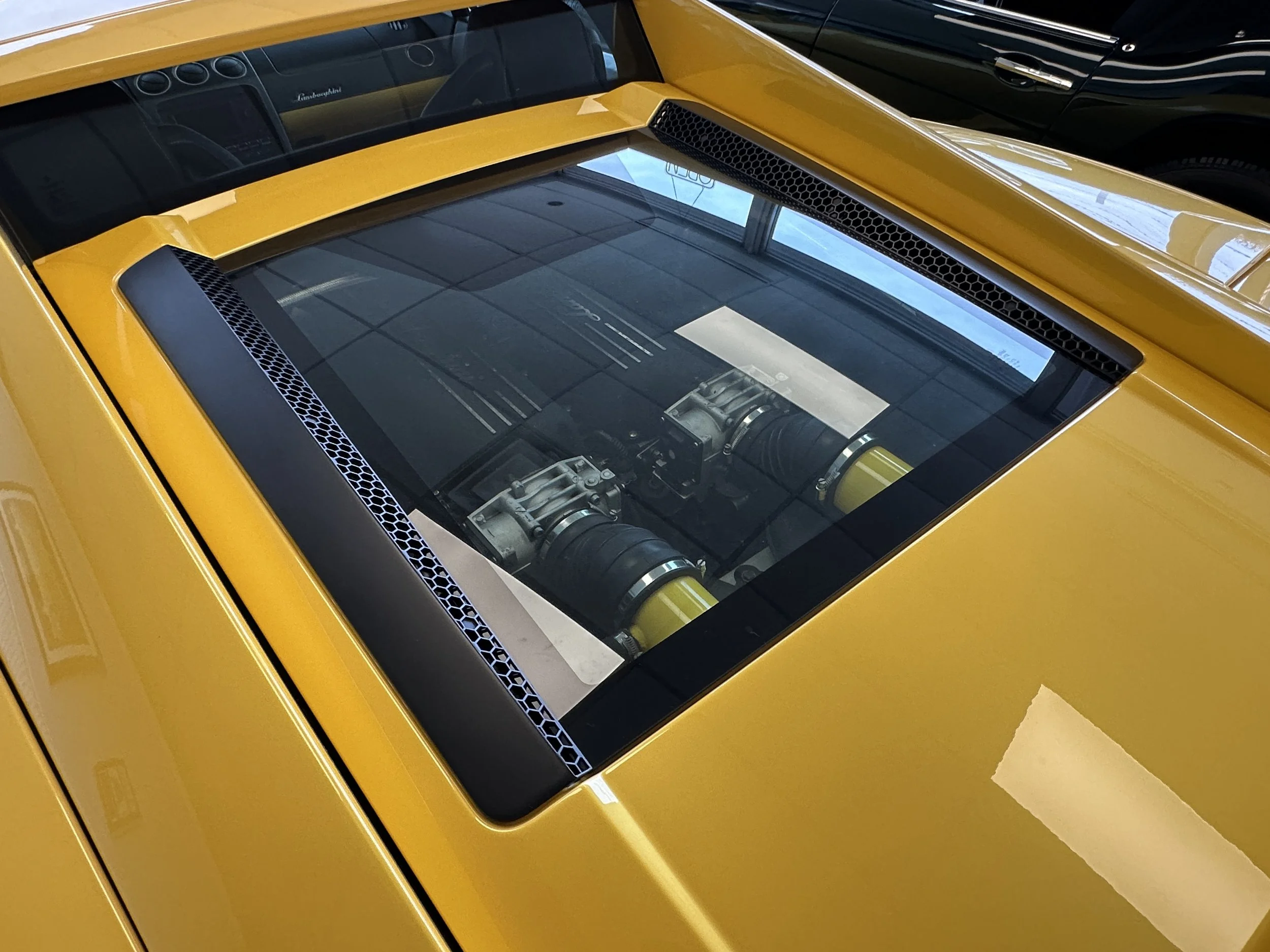 Yellow Lamborghini supercar with a transparent engine cover showing the engine inside.