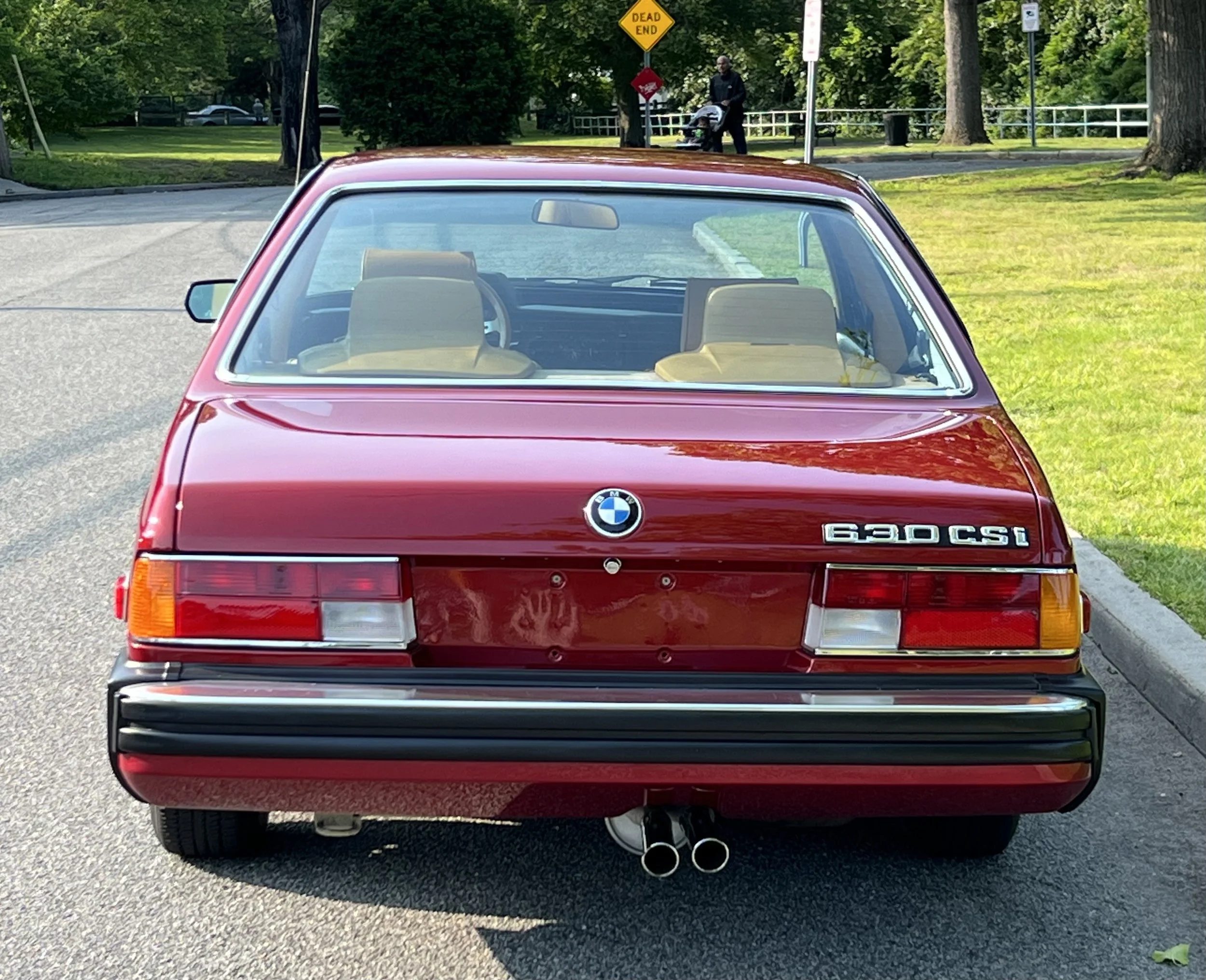 Back of Ruby Red 1977 BMW 630 csi on display in park for sale at FlowHaus