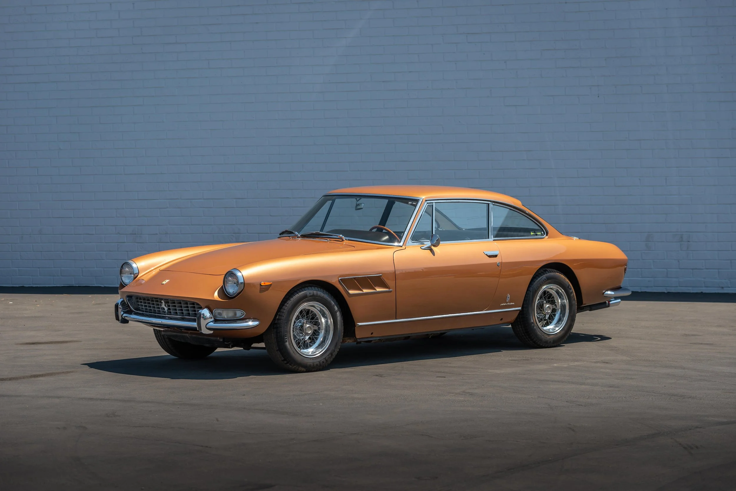 1967 Ferrari 330 GT Series II 2+2 on display near brick wall