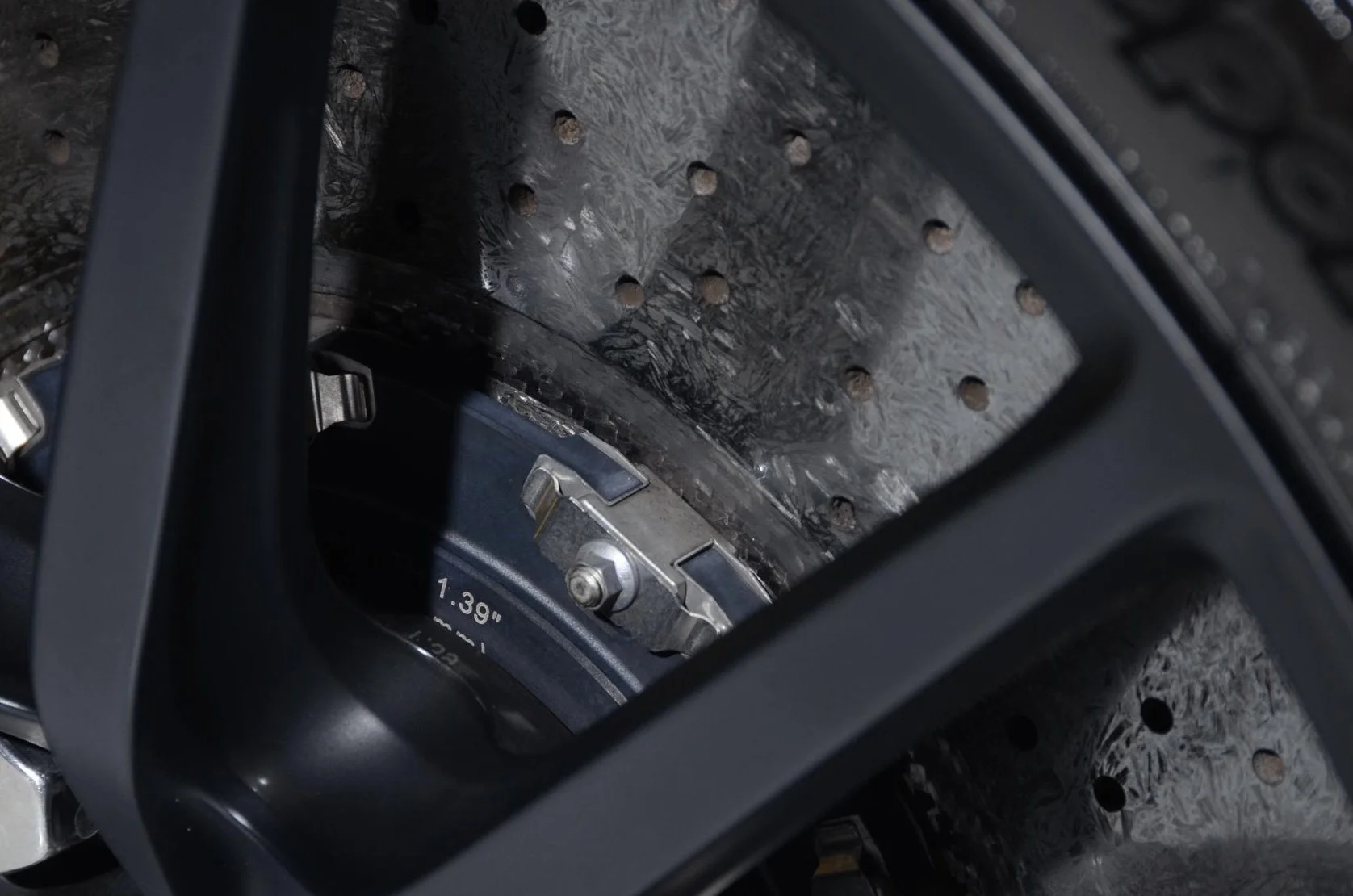 Close-up view of a mechanical or electronic device with metal components, screws, and a digital display showing 1.39