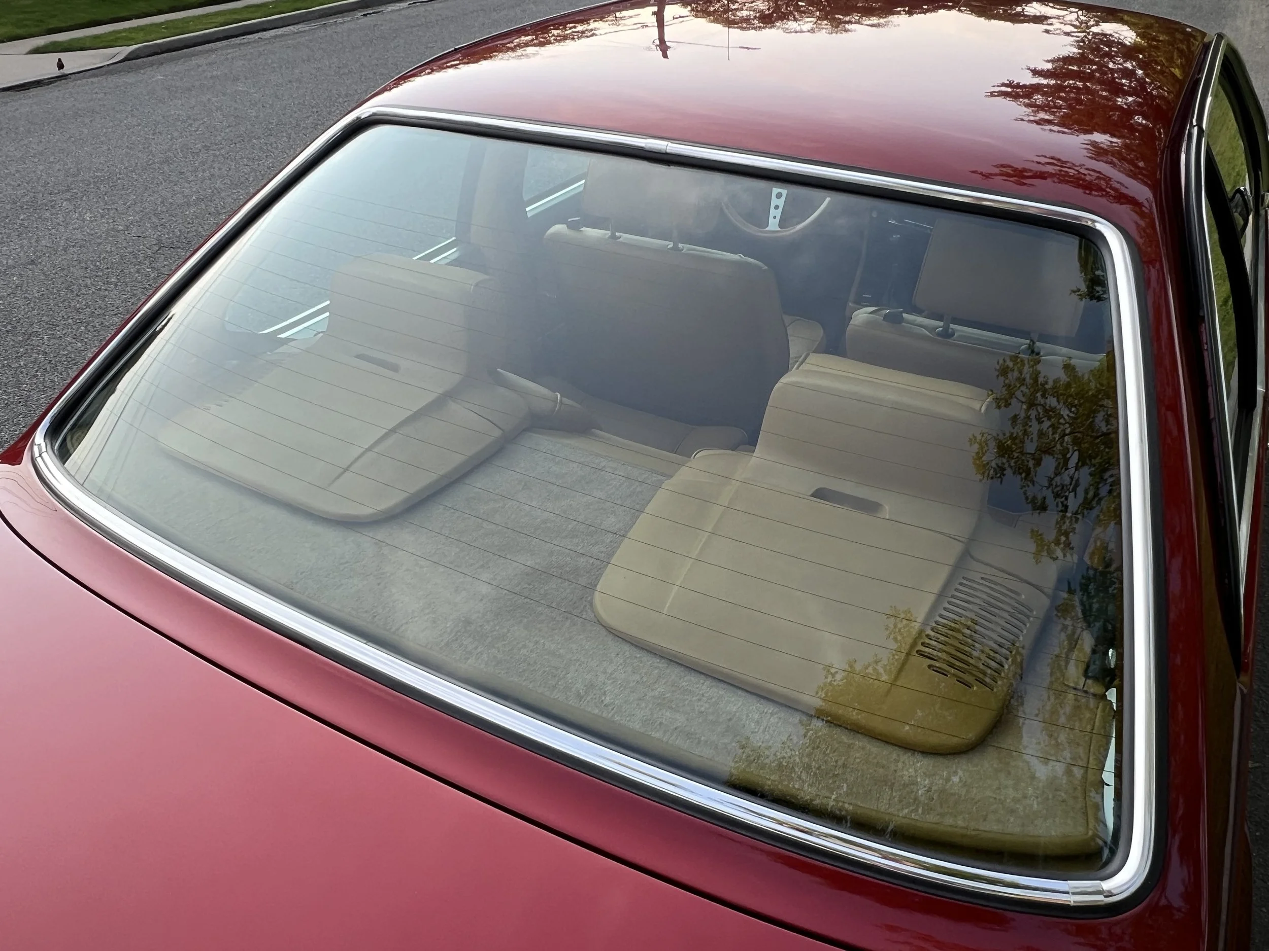 Red vintage BMW 630 csi car viewed from above through the rear windshield showing beige interior and headrests