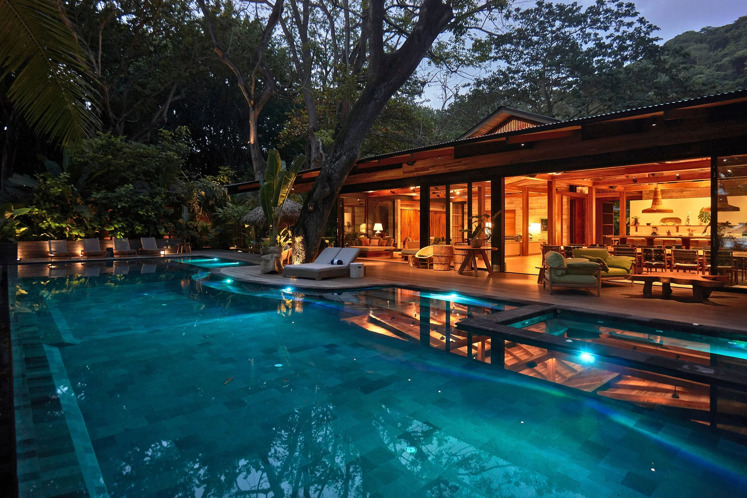 Young woman playing a cello with closed eyes in a colorful, artistic setting.