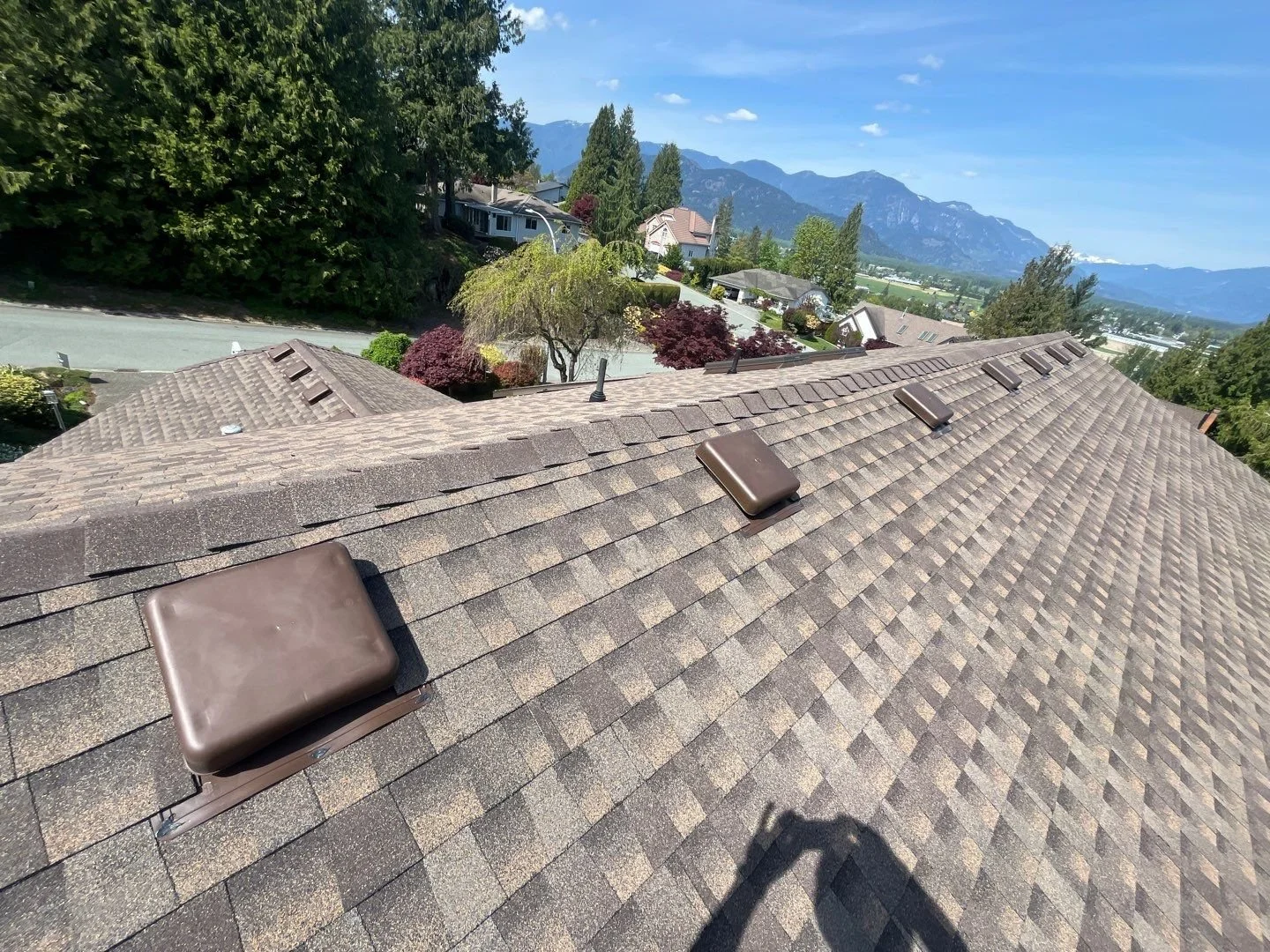 Residential roofing installation in Chilliwack by Top Notch Roofing, showing asphalt shingle roof with roof vents and mountain views in the Fraser Valley.