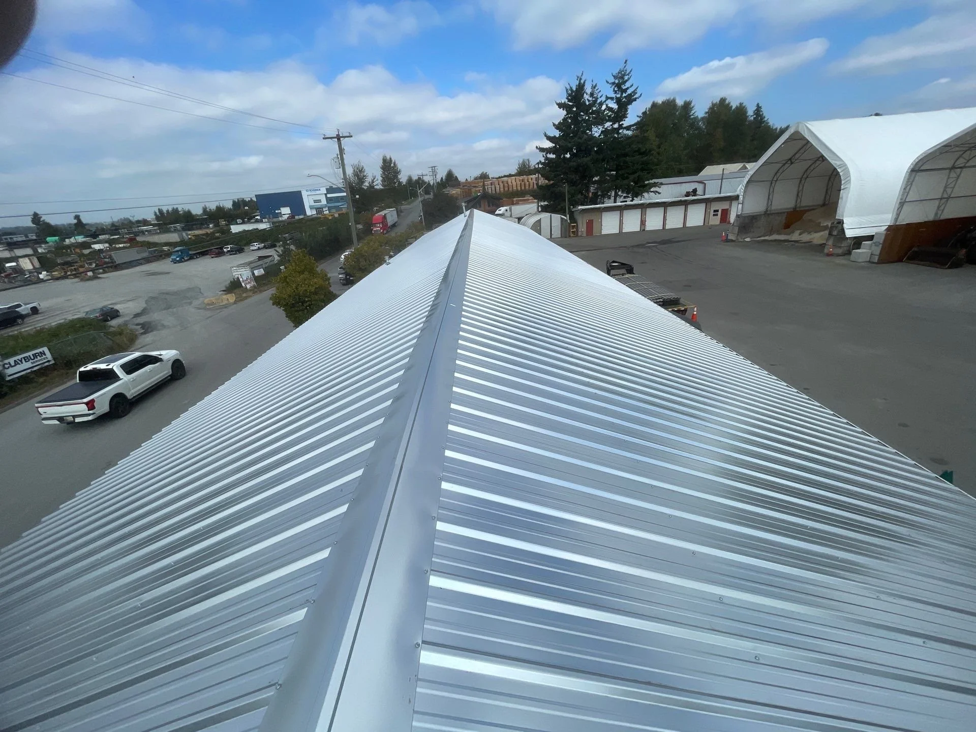Commercial re-roof project completed by Top Notch Roofing in the Fraser Valley, featuring a standing seam metal roof on an industrial building.