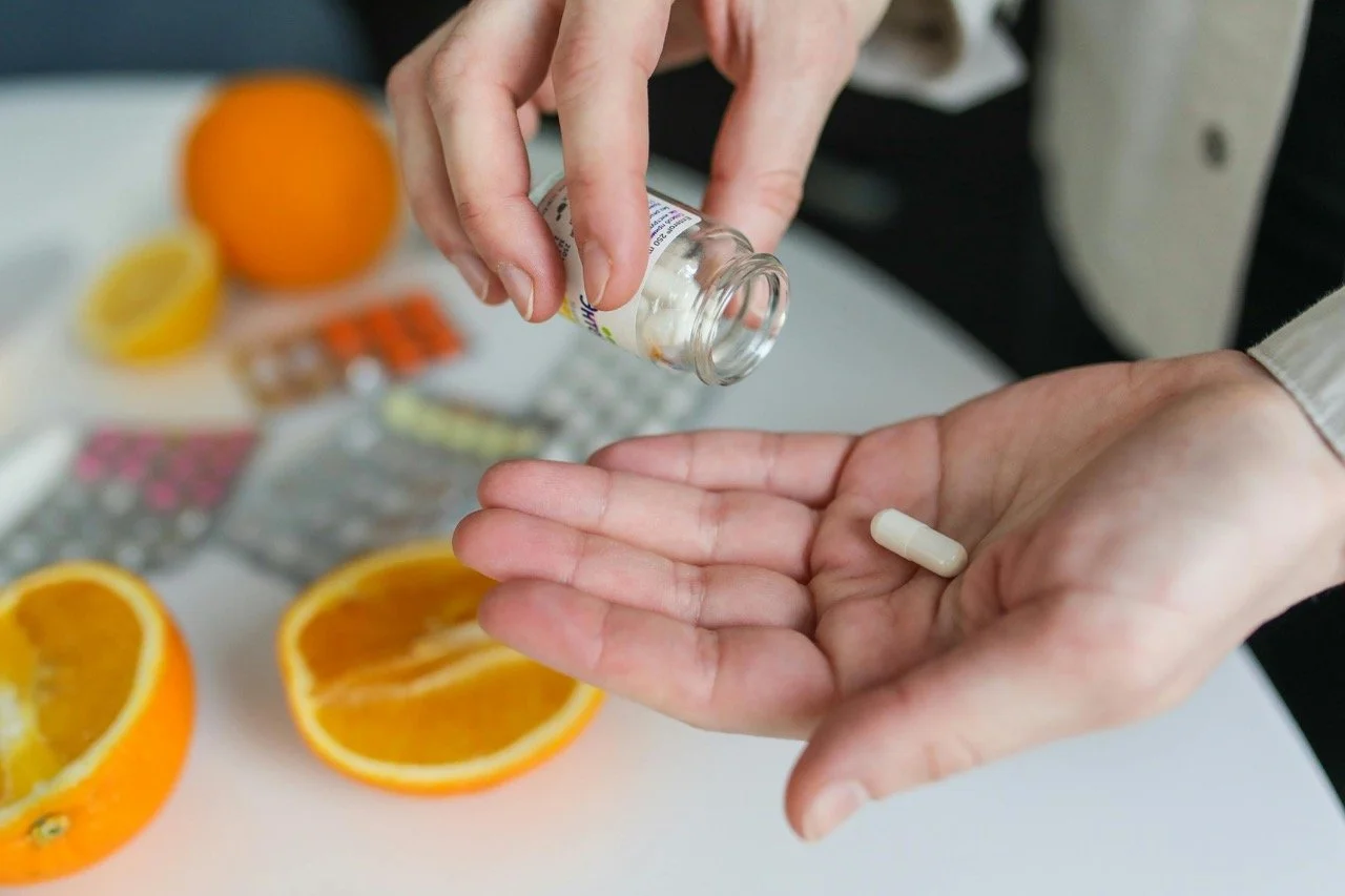 woman pouring supplements into her hand