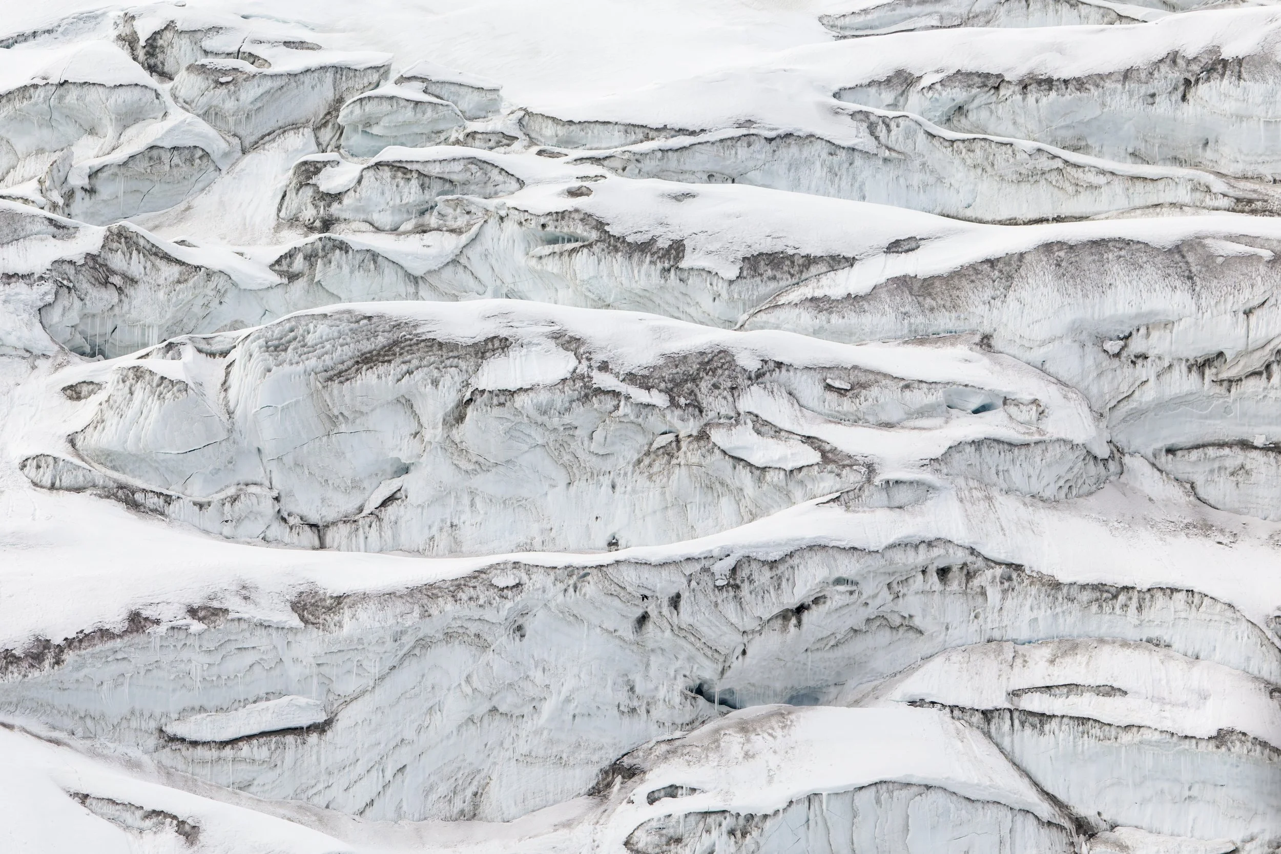 Close-up of fractured and layered ice and snow on a glacier or ice formation.