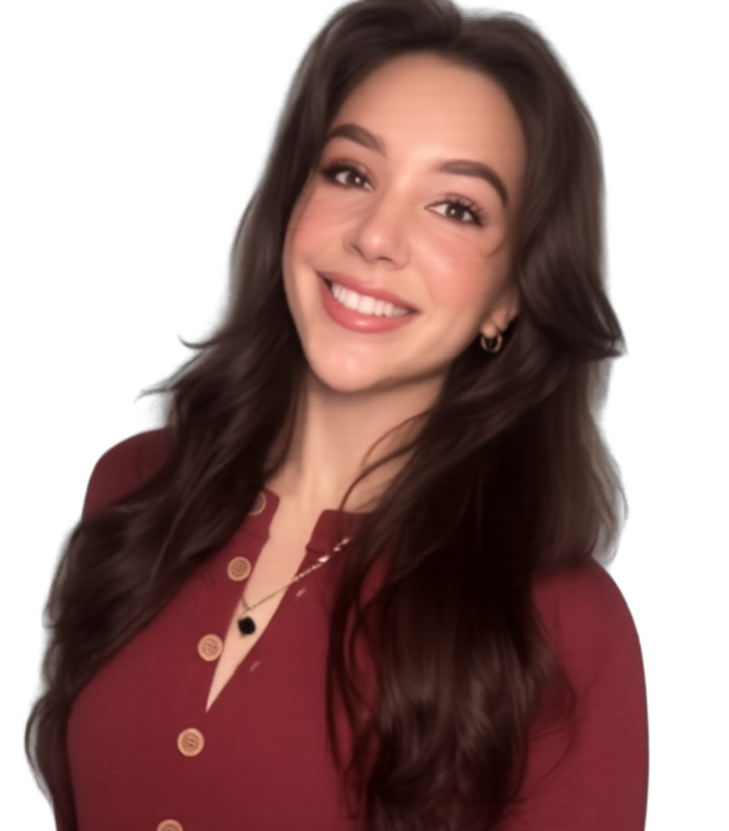 A young woman with long, wavy brown hair smiling at the camera, wearing a maroon button-up top and gold jewelry, standing against a plain wall.