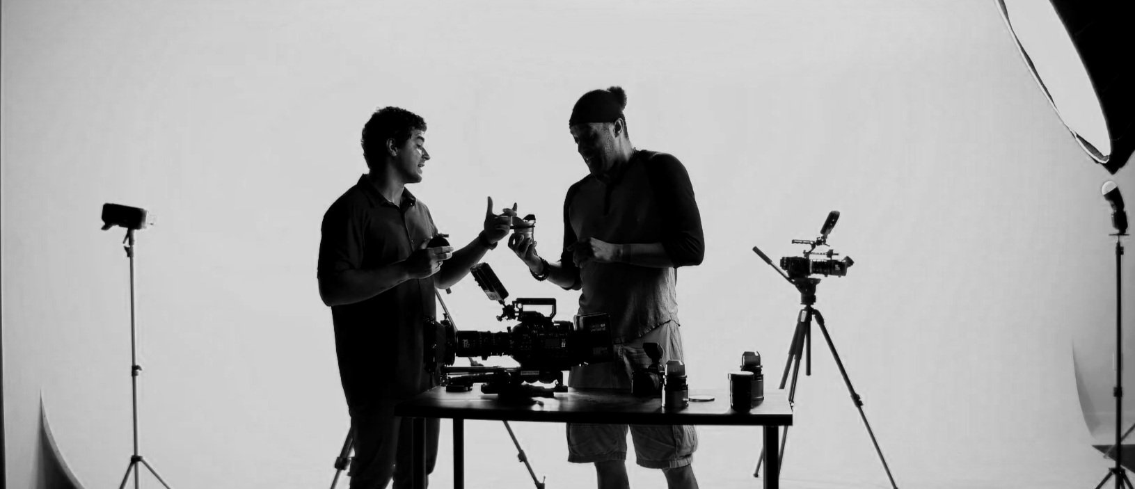Two people working with cameras in a professional studio with lighting equipment.