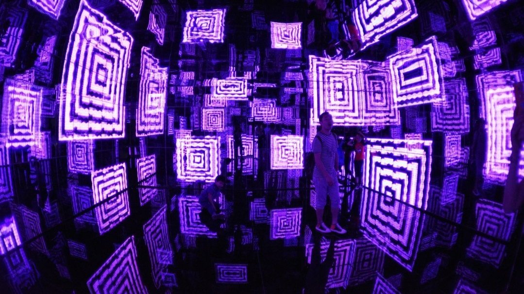 a person in a art tech exhibition with purple screens