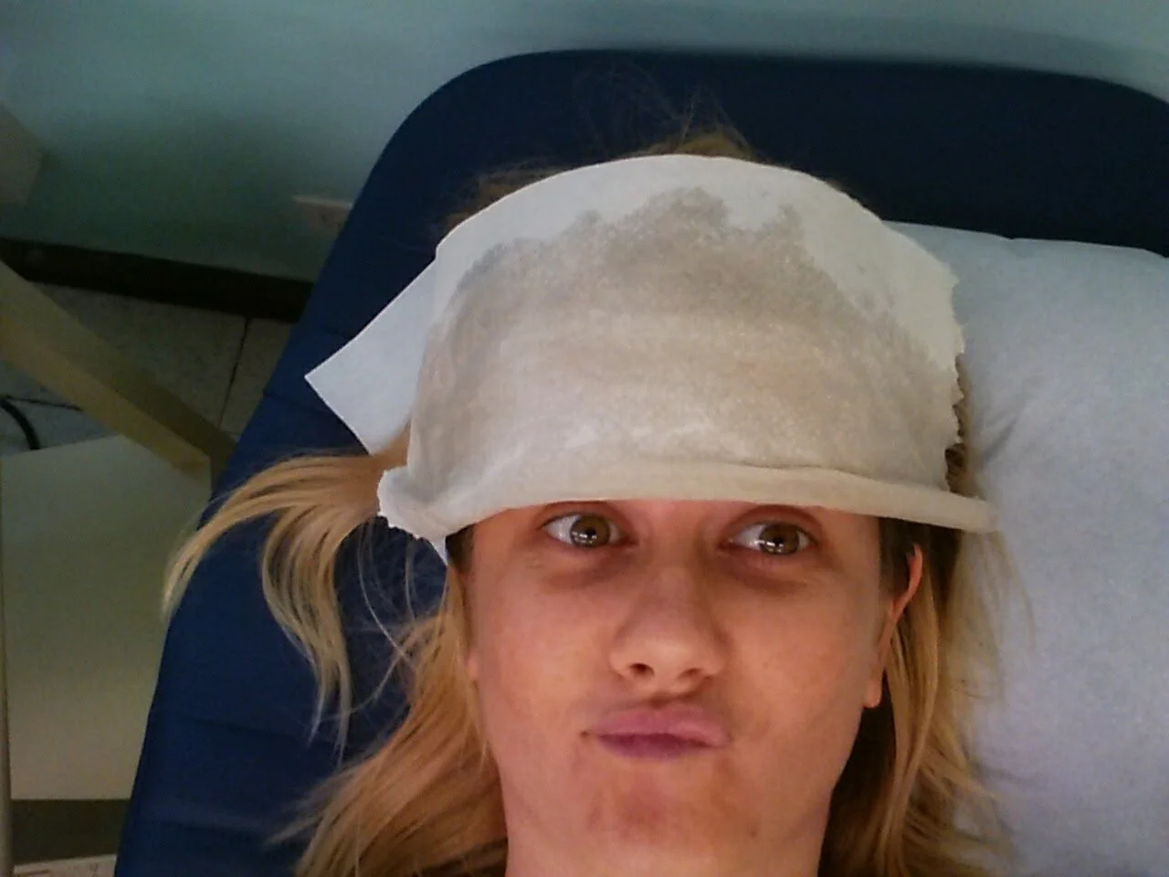 Woman cooling her forehead after giving blood at the Barbados Blood Collecting Centre, showing the light-hearted side of first-time blood donation.