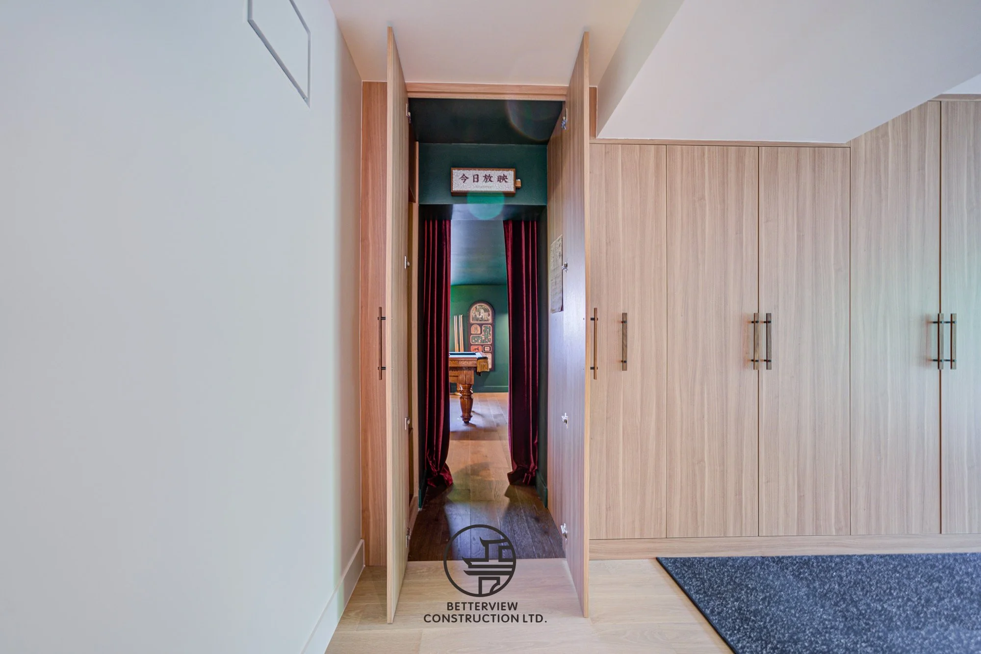 finished basement renovation with custom cabinetry and concealed door