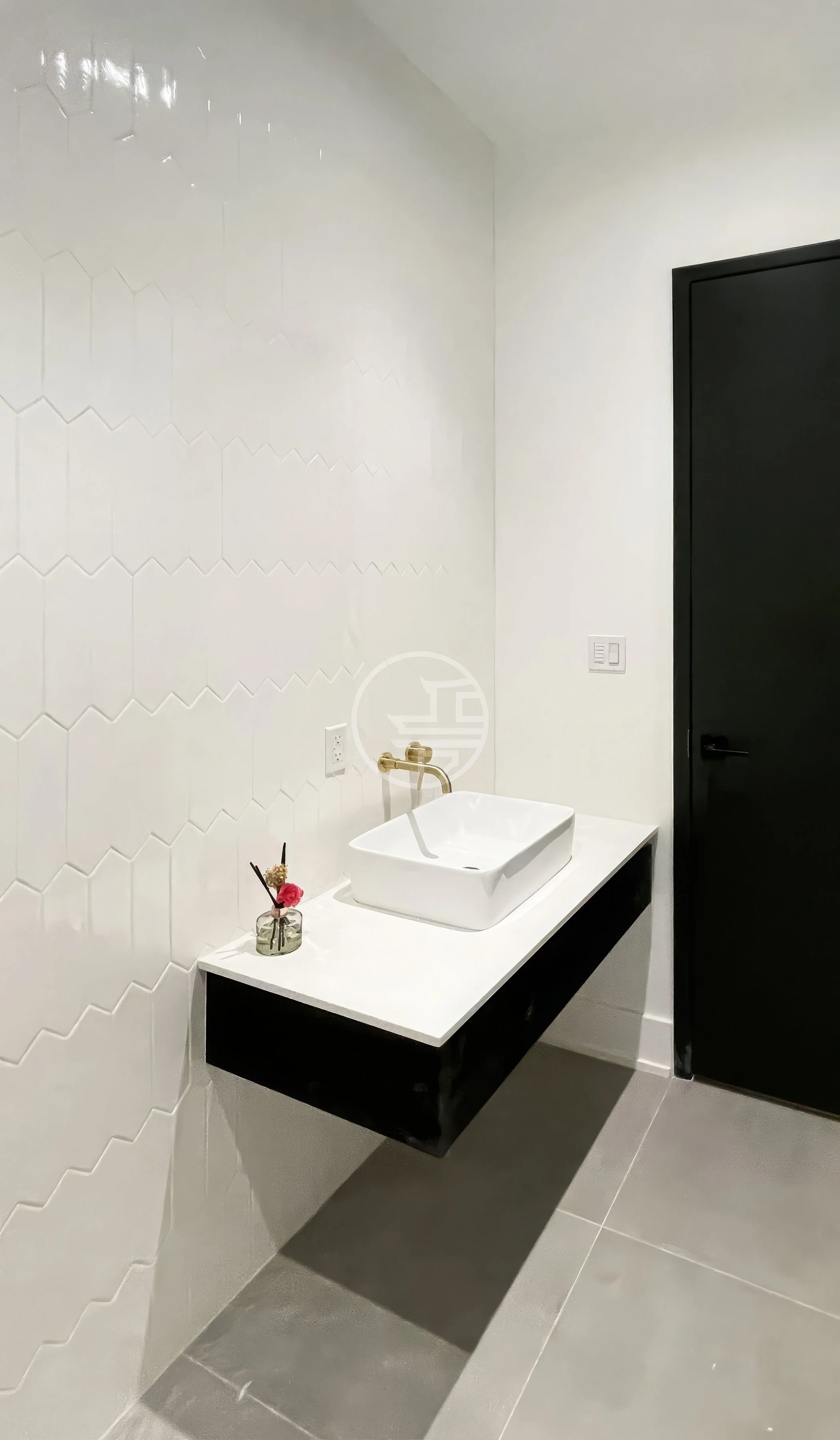 Commercial washroom renovation in Toronto featuring wall-mounted sink, tiled walls, and durable tile flooring for office restroom design