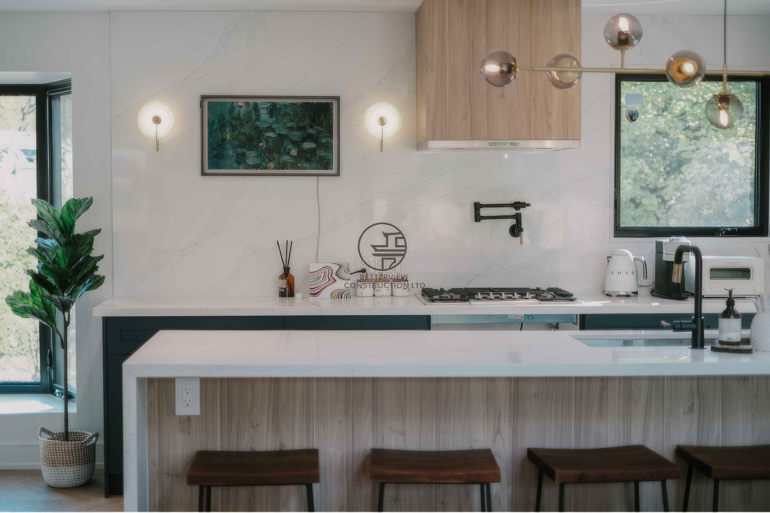 Modern kitchen renovation with white island seating, wood cabinetry, and contemporary lighting in a Toronto home.