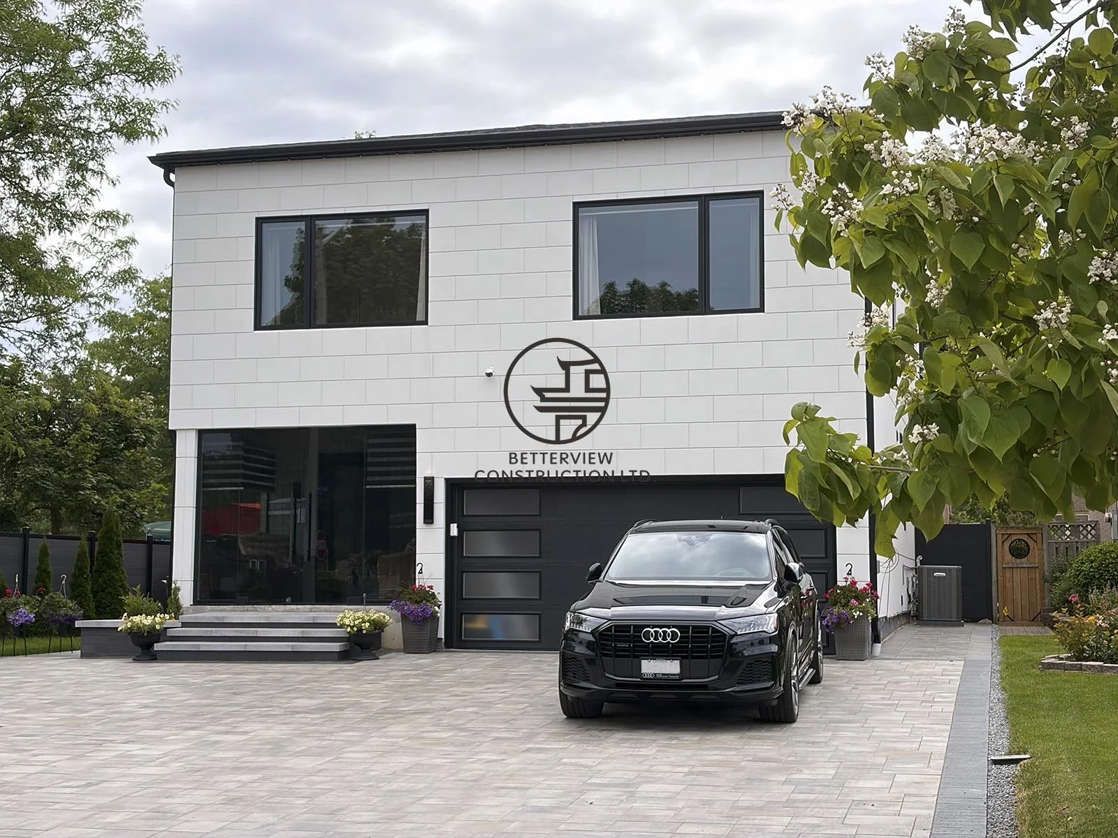 The front elevation showcases a thoughtfully designed home addition with modern architectural lines, premium exterior finishes, and large windows that blend beautifully with the existing residence.