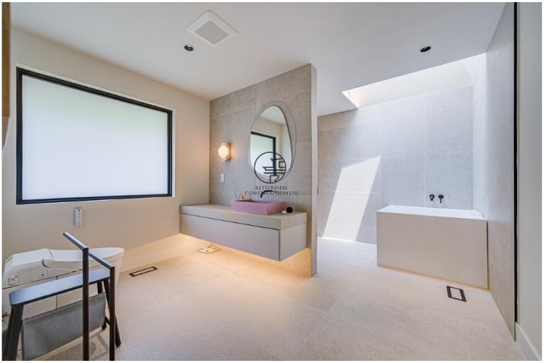 Modern bathroom renovation featuring a custom floating vanity, skylight, minimalist finishes, and natural light in a GTA home
