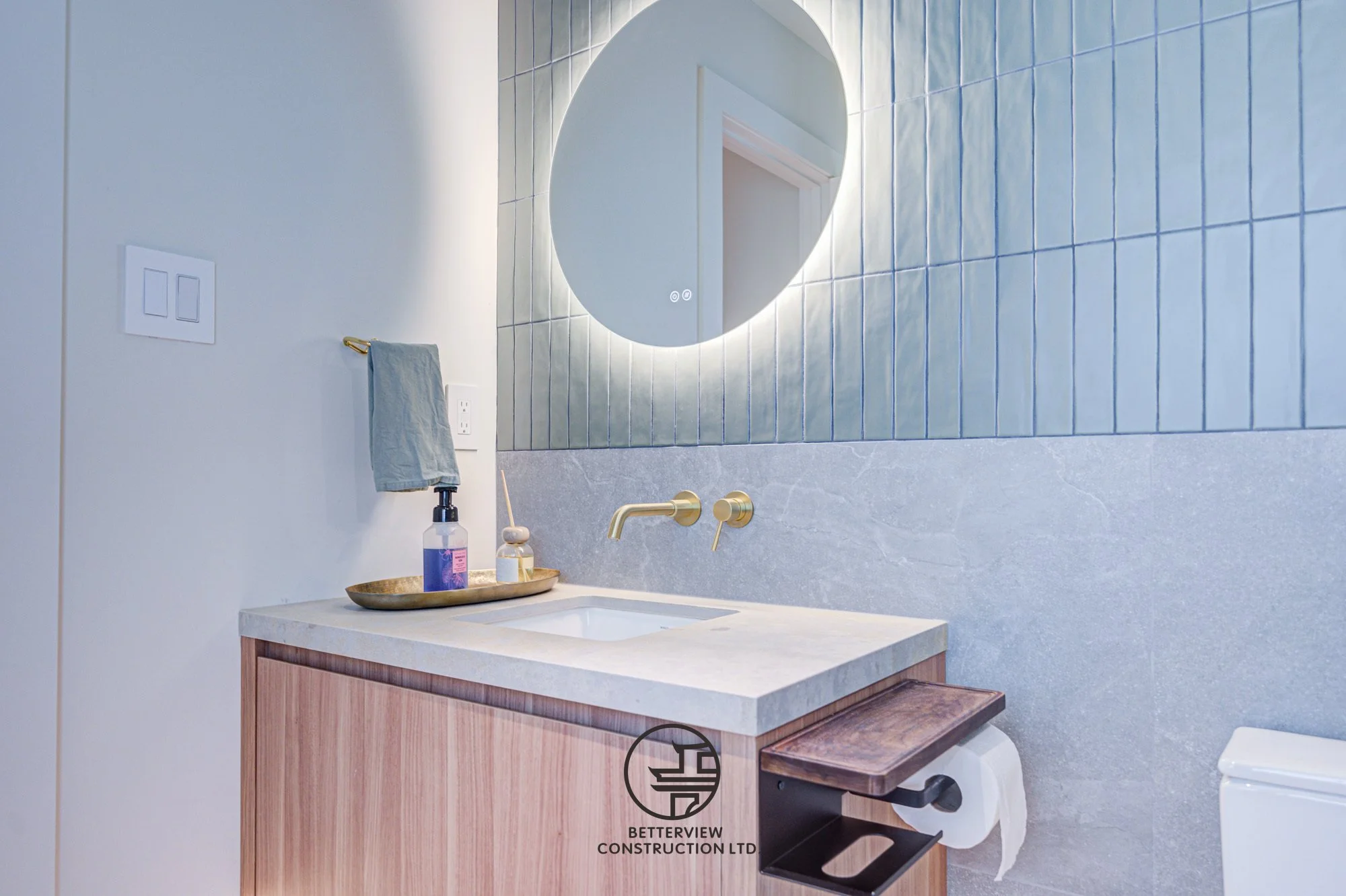 modern guest bathroom vanity with round LED mirror and wood cabinet