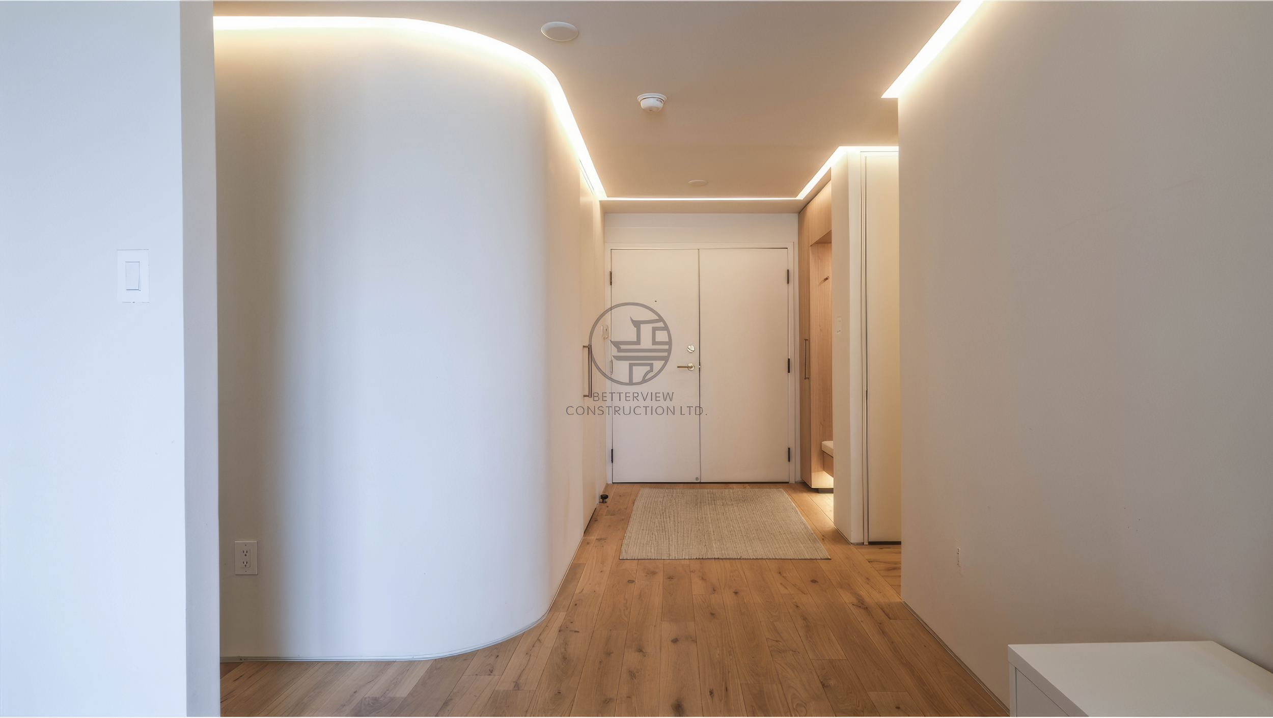 modern entry hallway with curved wall and LED ceiling lighting