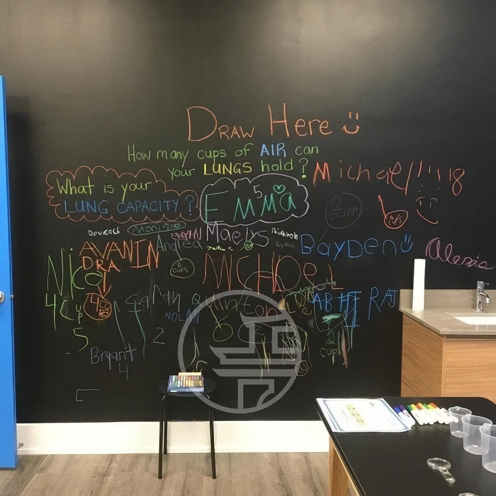 Commercial interior renovation in Toronto featuring a chalkboard feature wall, custom workspace, and modern retail design elements