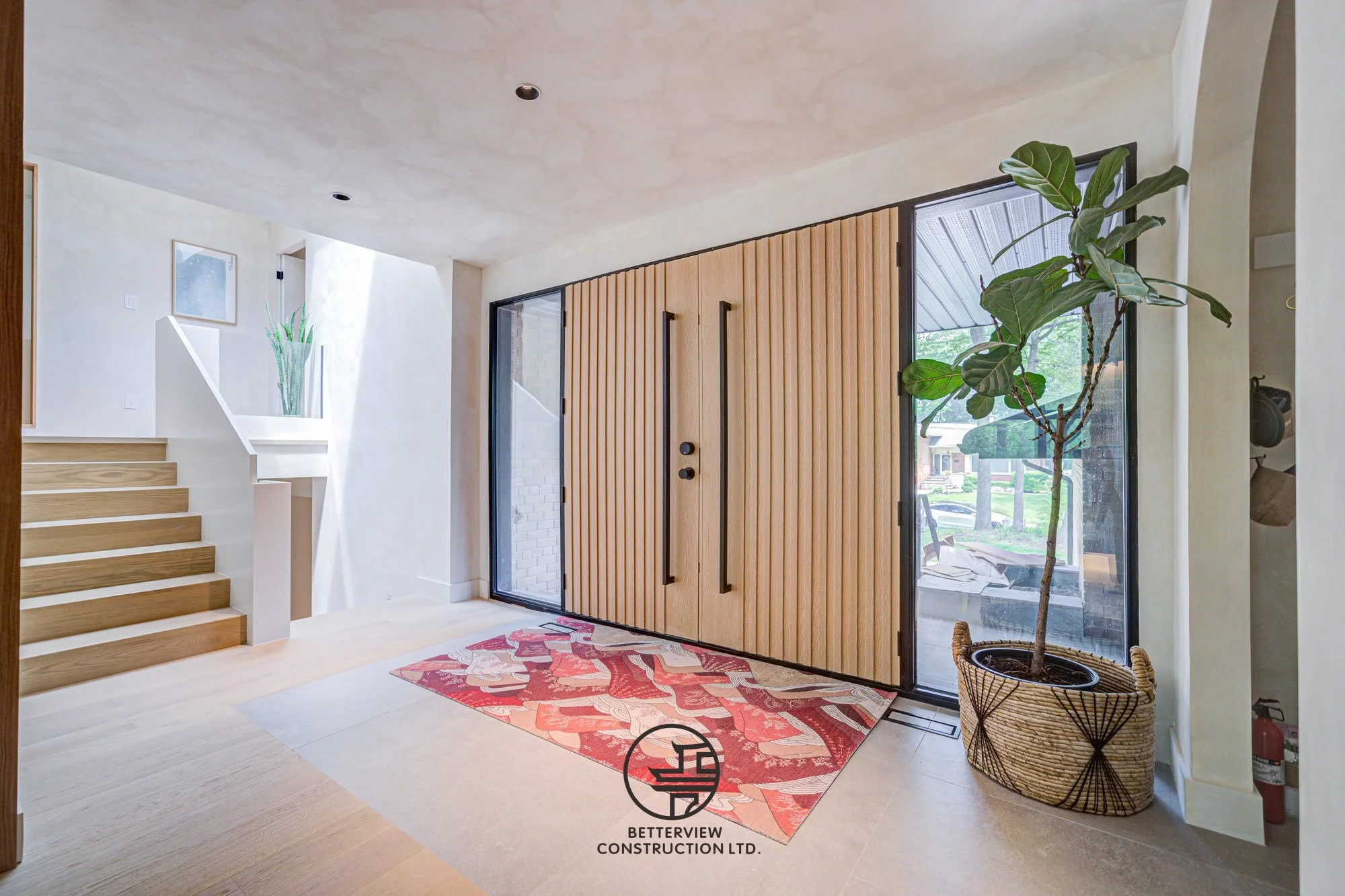 modern home entryway with wood front door and staircase design