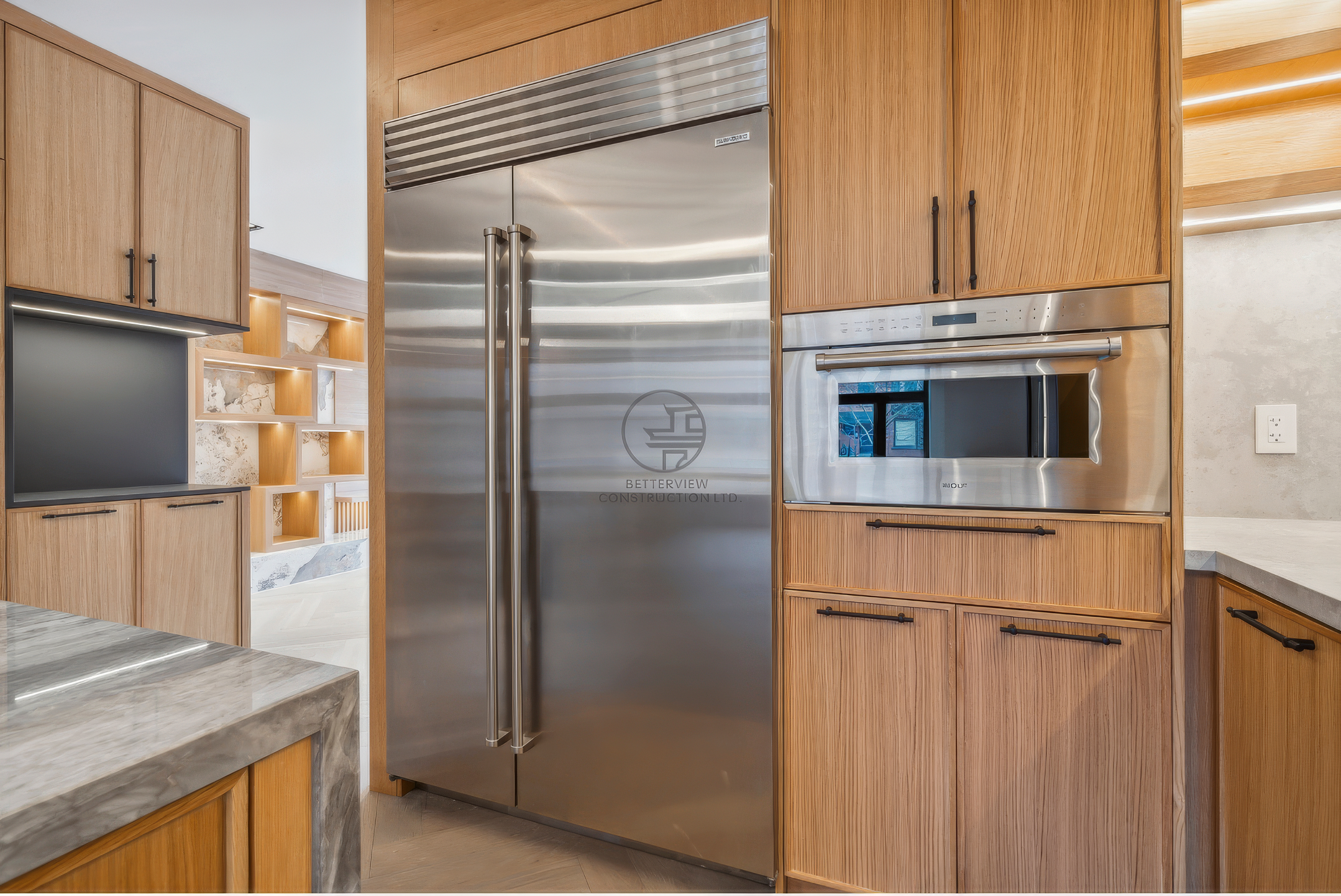 Modern kitchen with custom wood cabinetry, built-in stainless steel refrigerator and oven, quartz countertops, and integrated storage in a luxury home renovation project