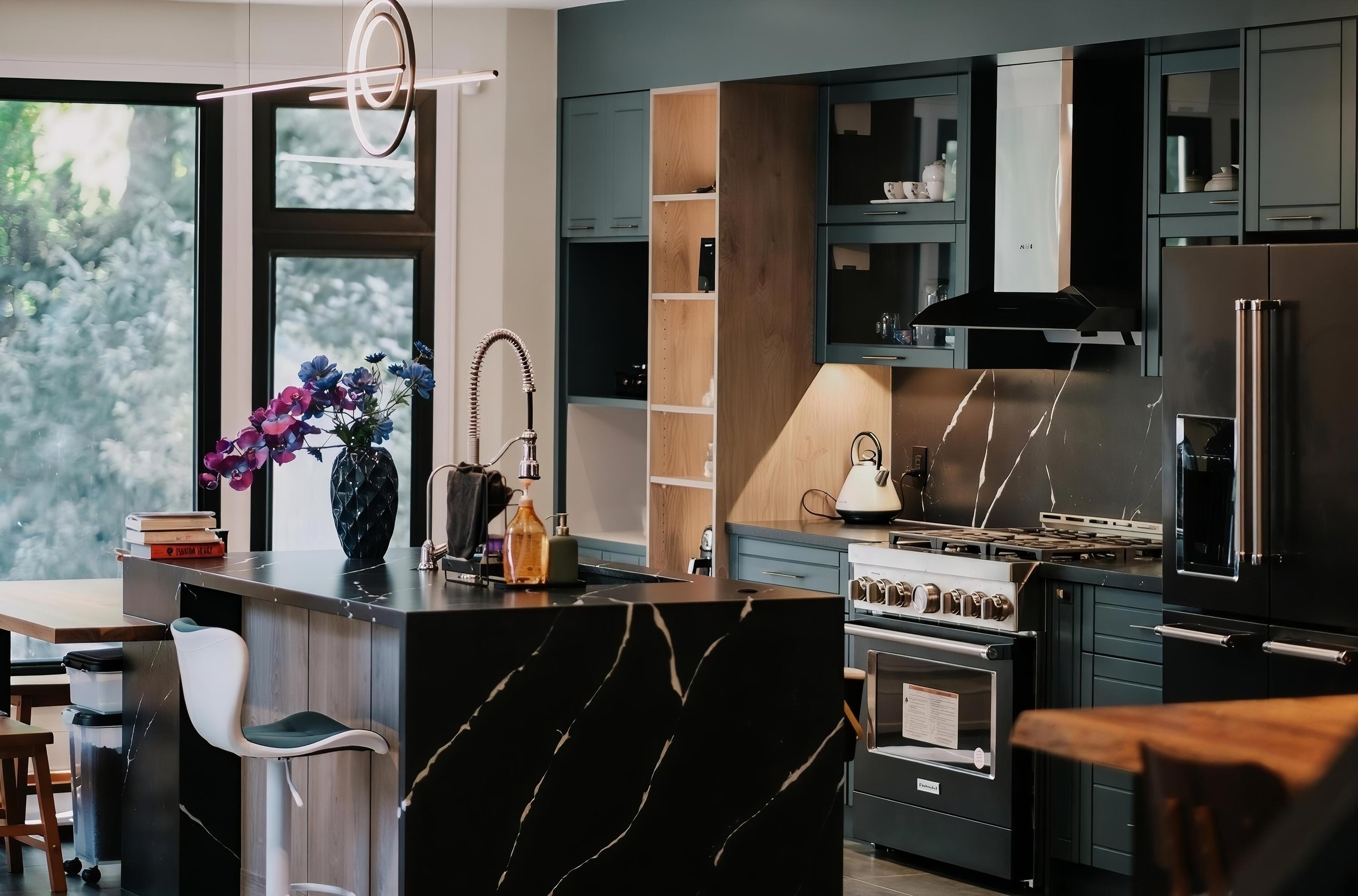 Modern kitchen renovation featuring dark cabinetry, custom island, integrated appliances, and contemporary lighting in a GTA home