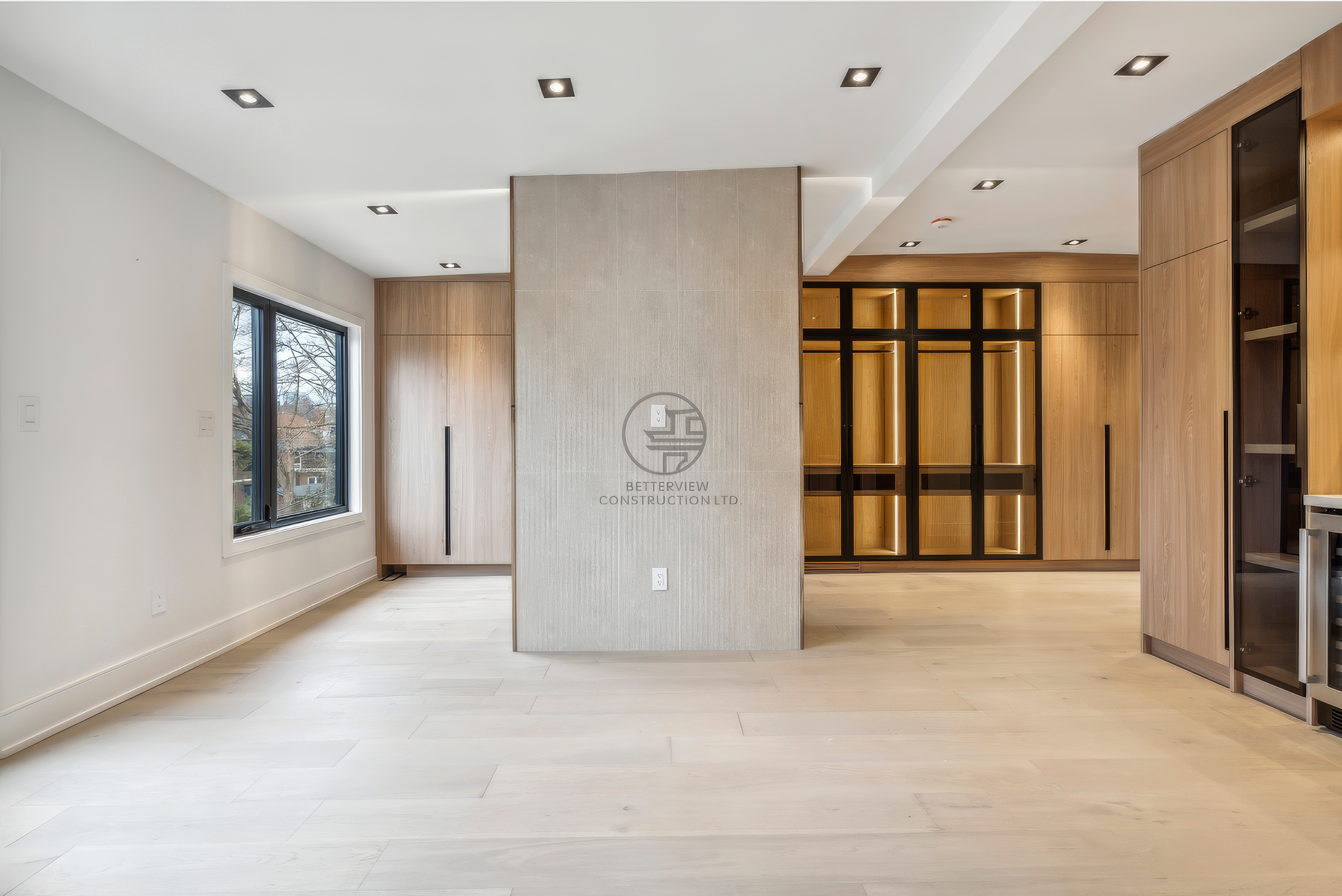 Modern open living area with feature wall, built-in cabinetry, recessed lighting, and minimalist contemporary interior design.
