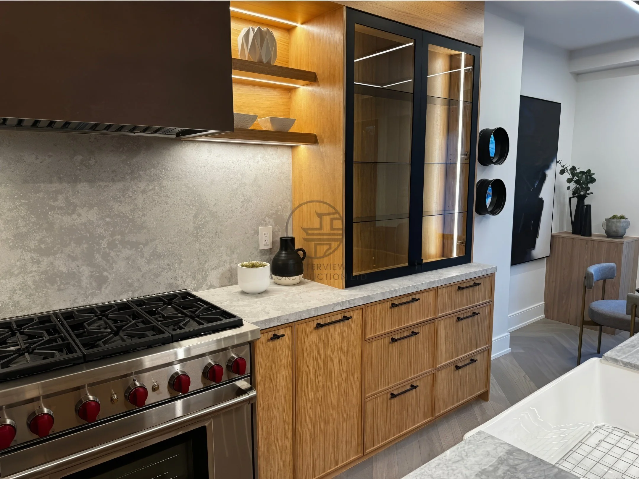 Modern kitchen with custom wood cabinets, glass display cabinet, quartz countertop, and stainless steel gas range in a luxury home renovation project