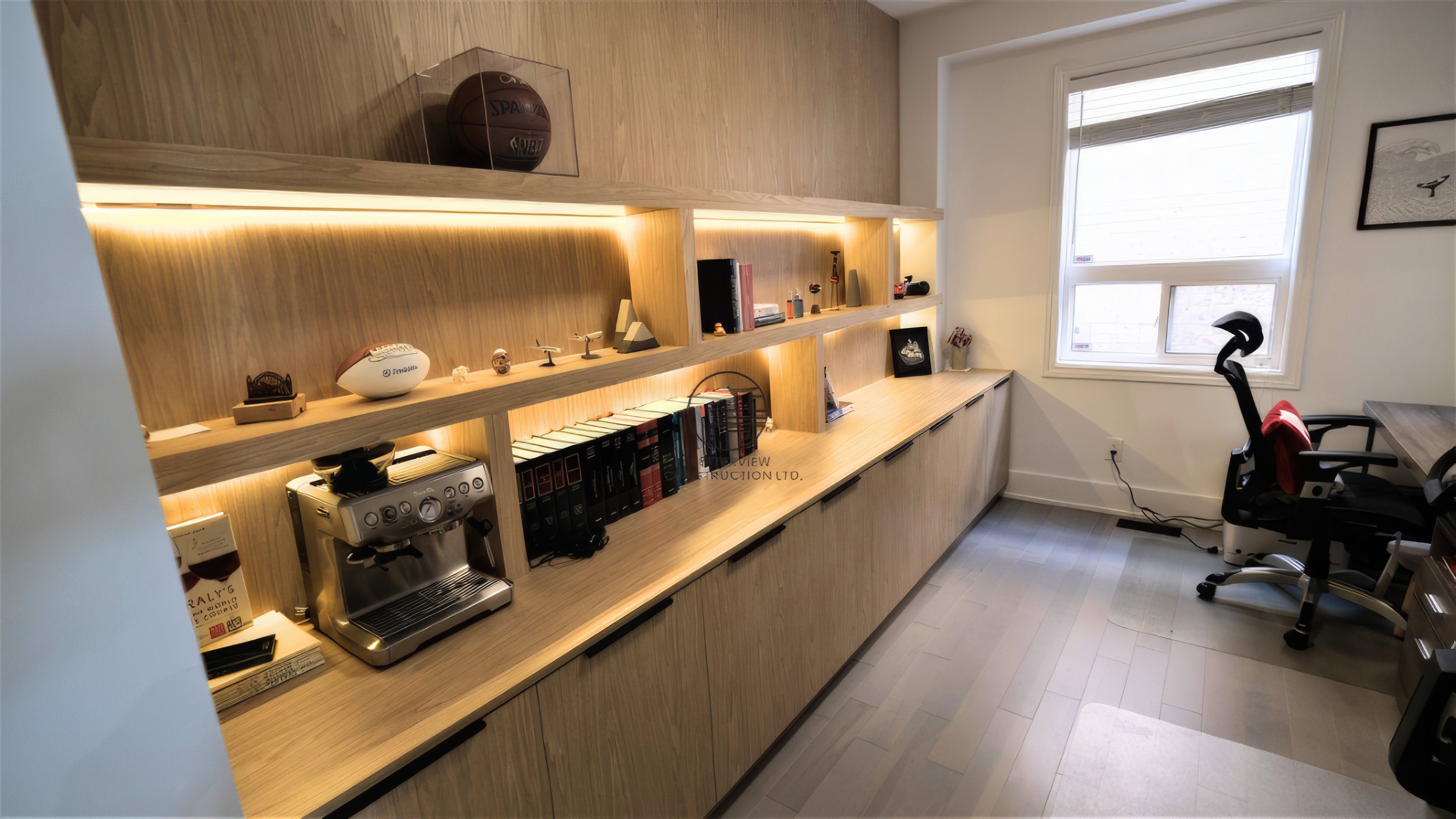 modern basement renovation with custom built in cabinetry and illuminated display shelves