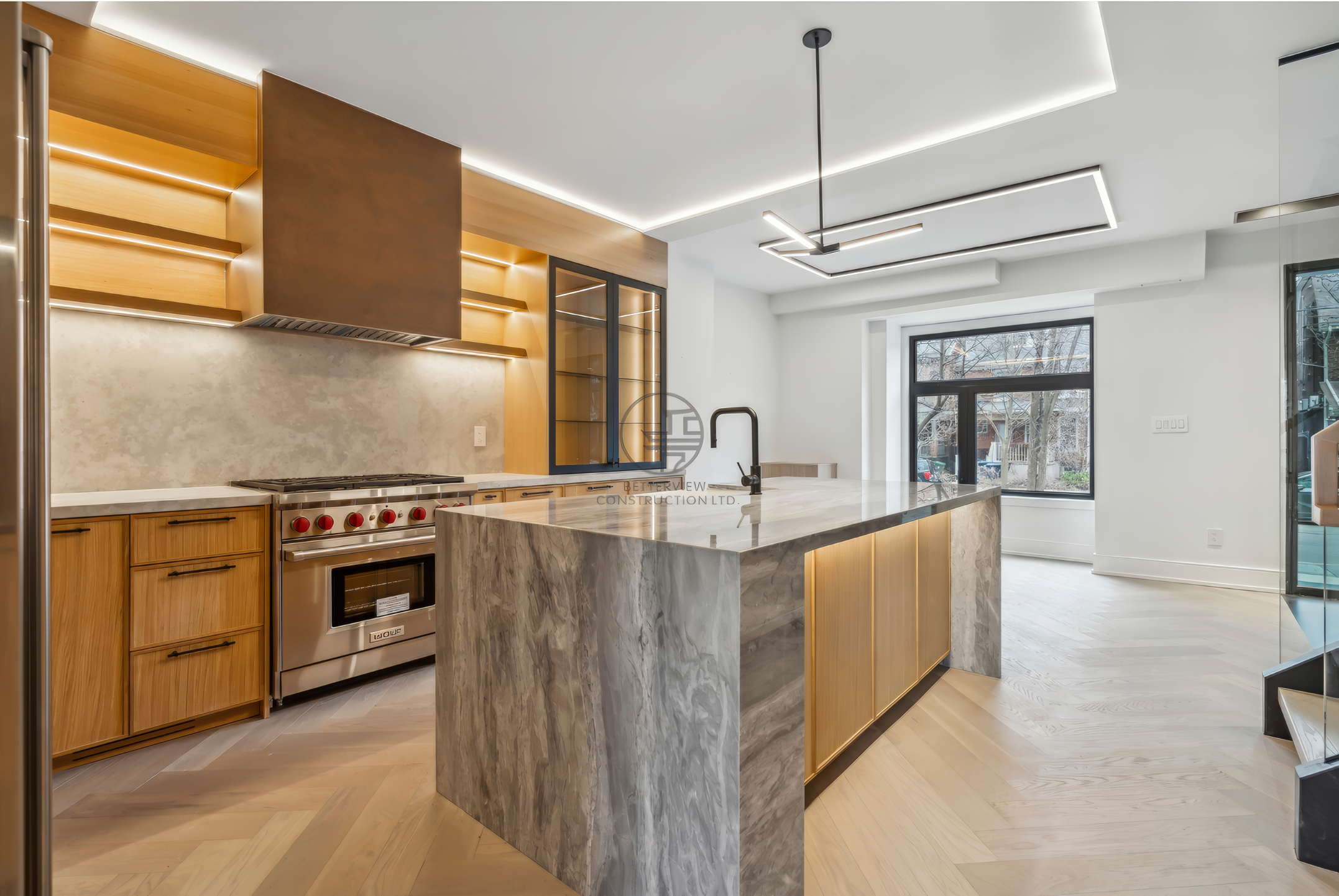Modern kitchen with marble waterfall island, wood cabinetry, gas range, open shelving, and LED ceiling lighting in contemporary design.