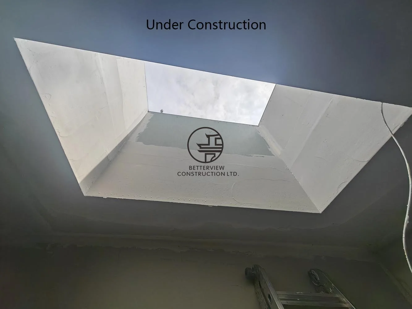 Finished skylight shaft bringing natural daylight into the modern interior and enhancing the open concept design.