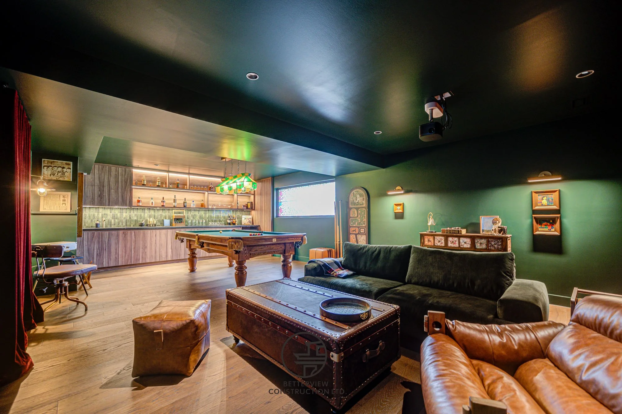 modern basement renovation with lounge area billiards table and custom bar