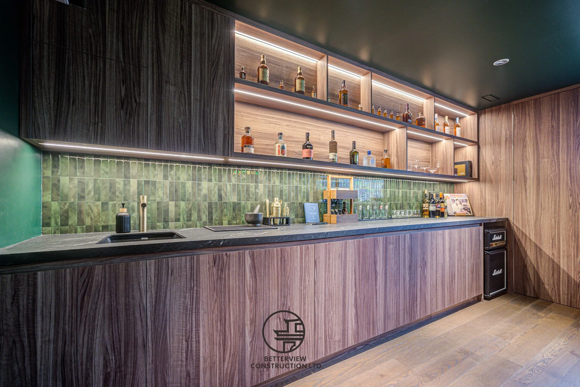 modern basement renovation with custom home bar and built in shelving