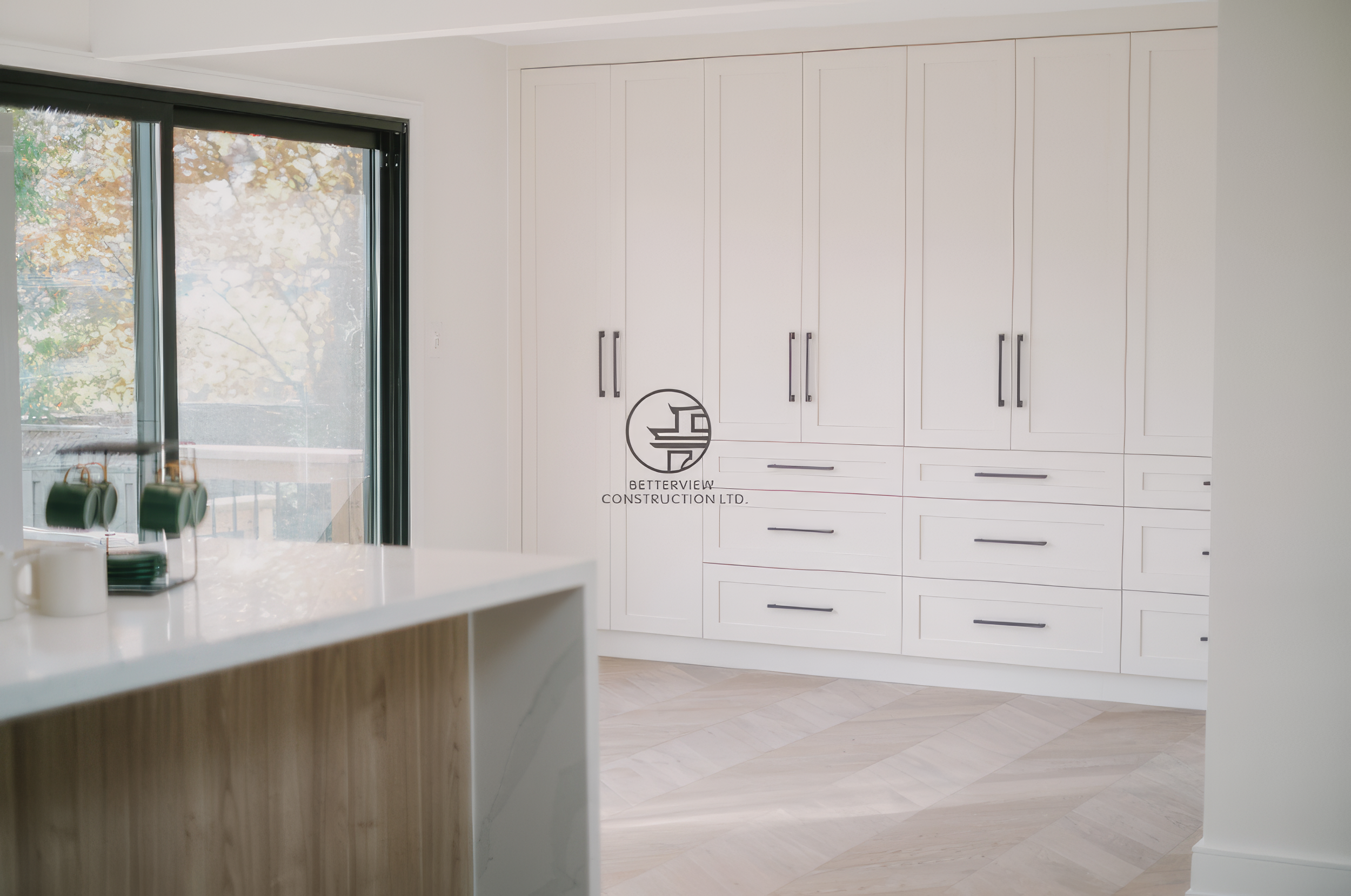 Modern kitchen renovation with custom white cabinetry, large storage wall, and minimalist interior design in a Toronto home.