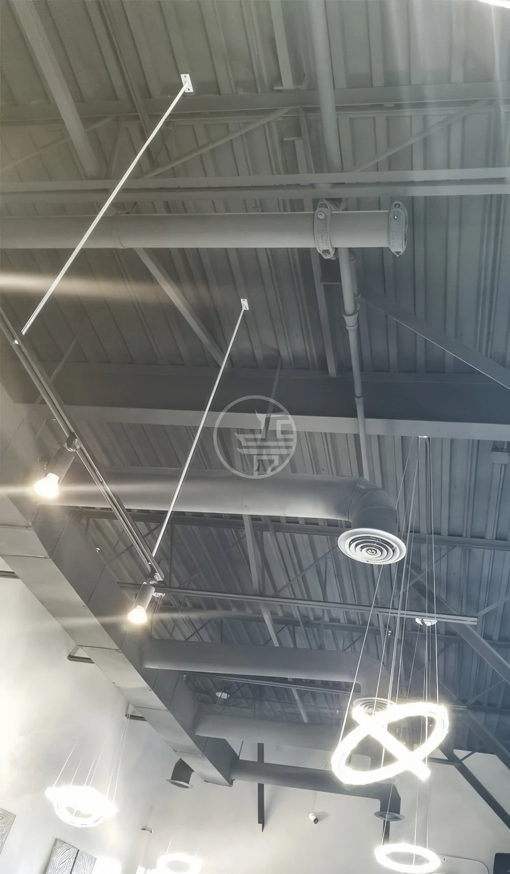 Commercial ceiling design in Toronto featuring exposed HVAC ductwork, industrial structure, and modern pendant lighting installation