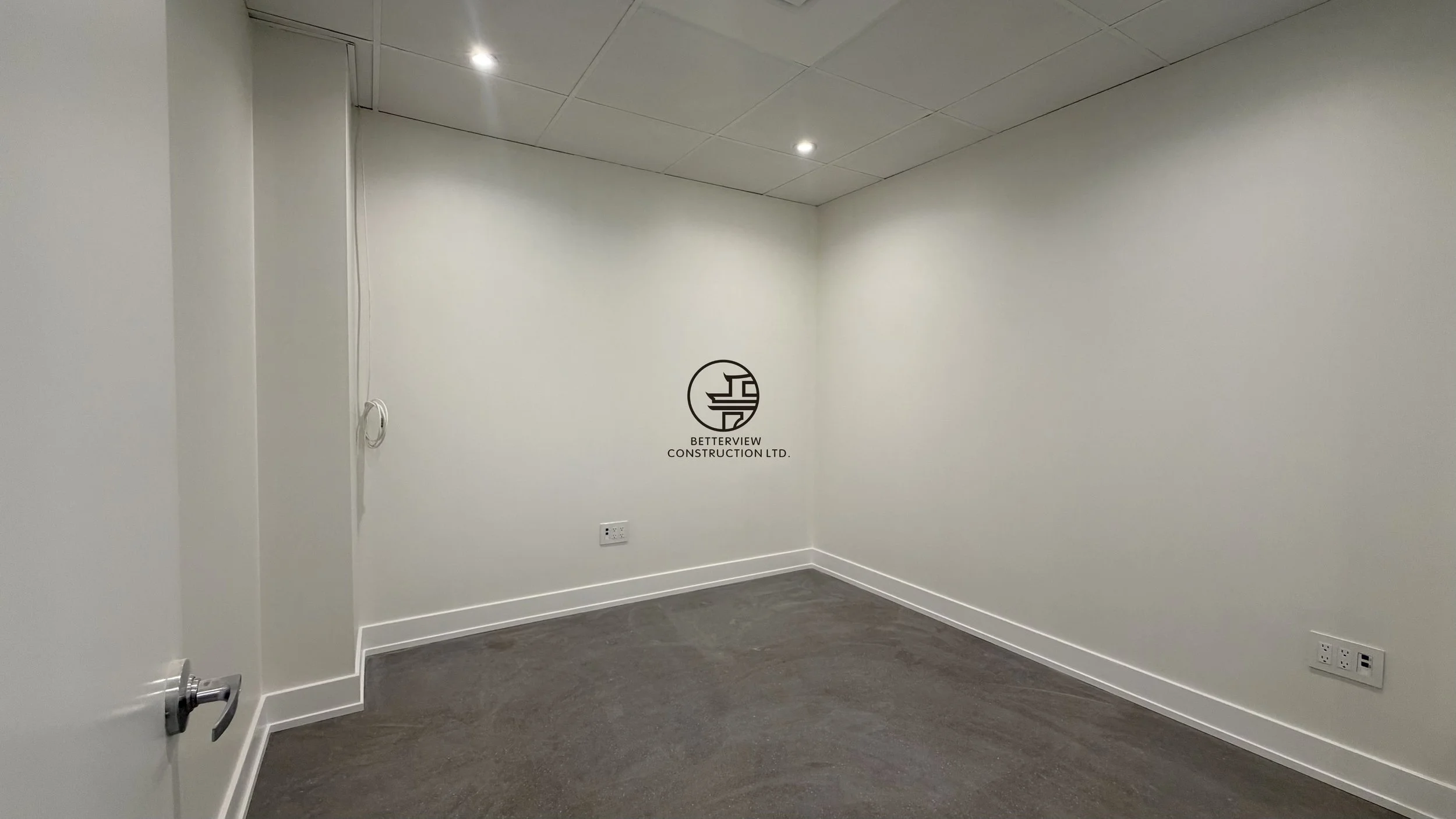 Small office room with recessed lighting, carpet flooring, and clean minimalist interior after renovation