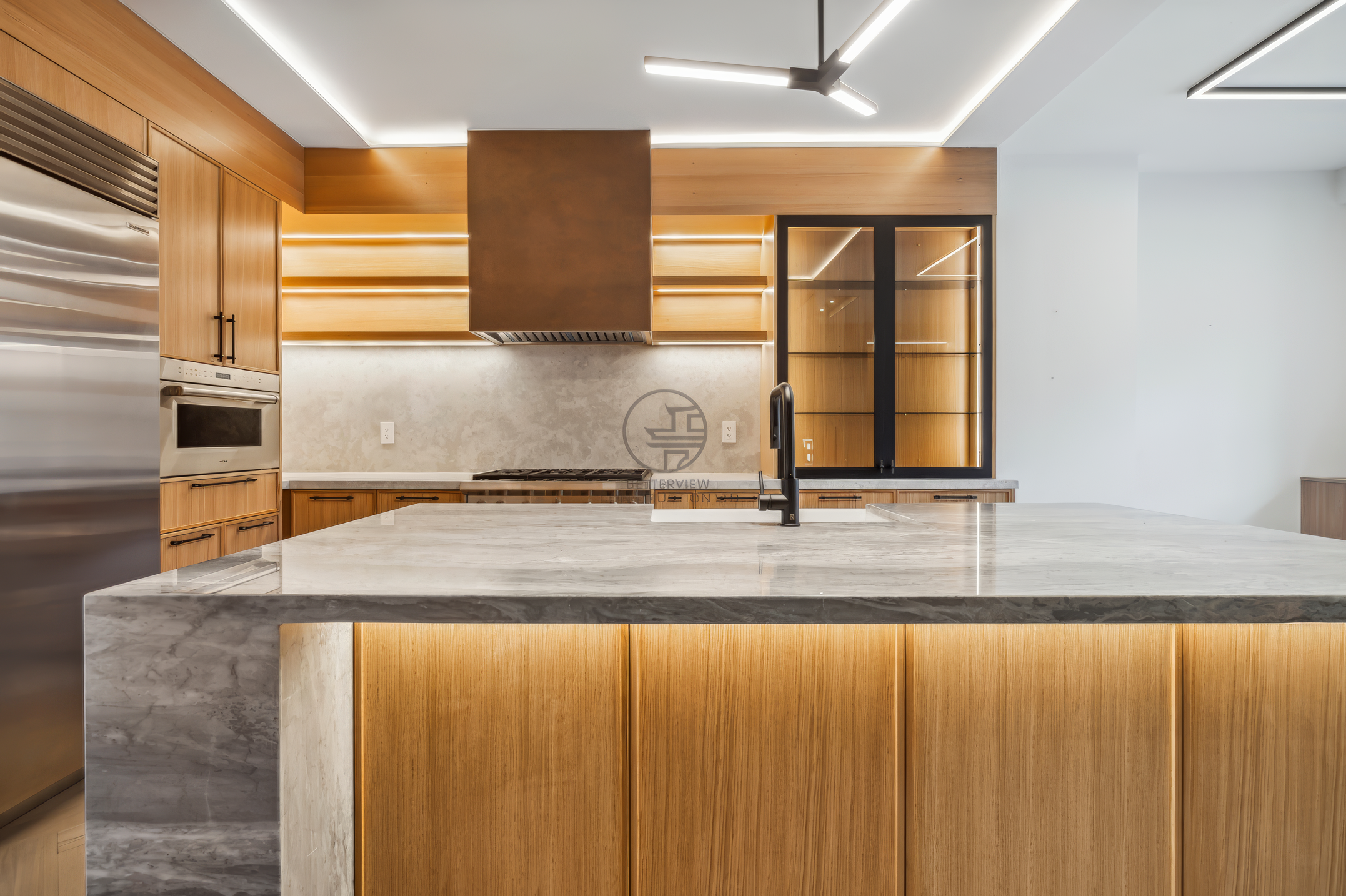 Modern kitchen with marble island, wood cabinetry, LED under-cabinet lighting, open shelving, and stainless steel appliances in contemporary design.