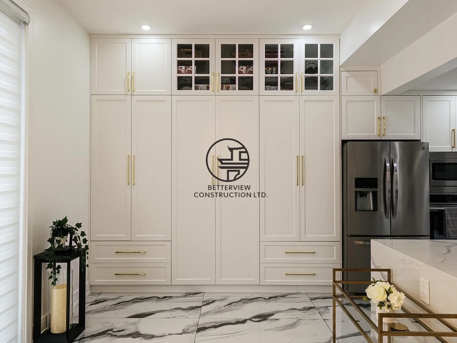 This custom storage wall features full-height cabinetry with integrated pantry storage, maximizing organization while maintaining a clean and sophisticated appearance.