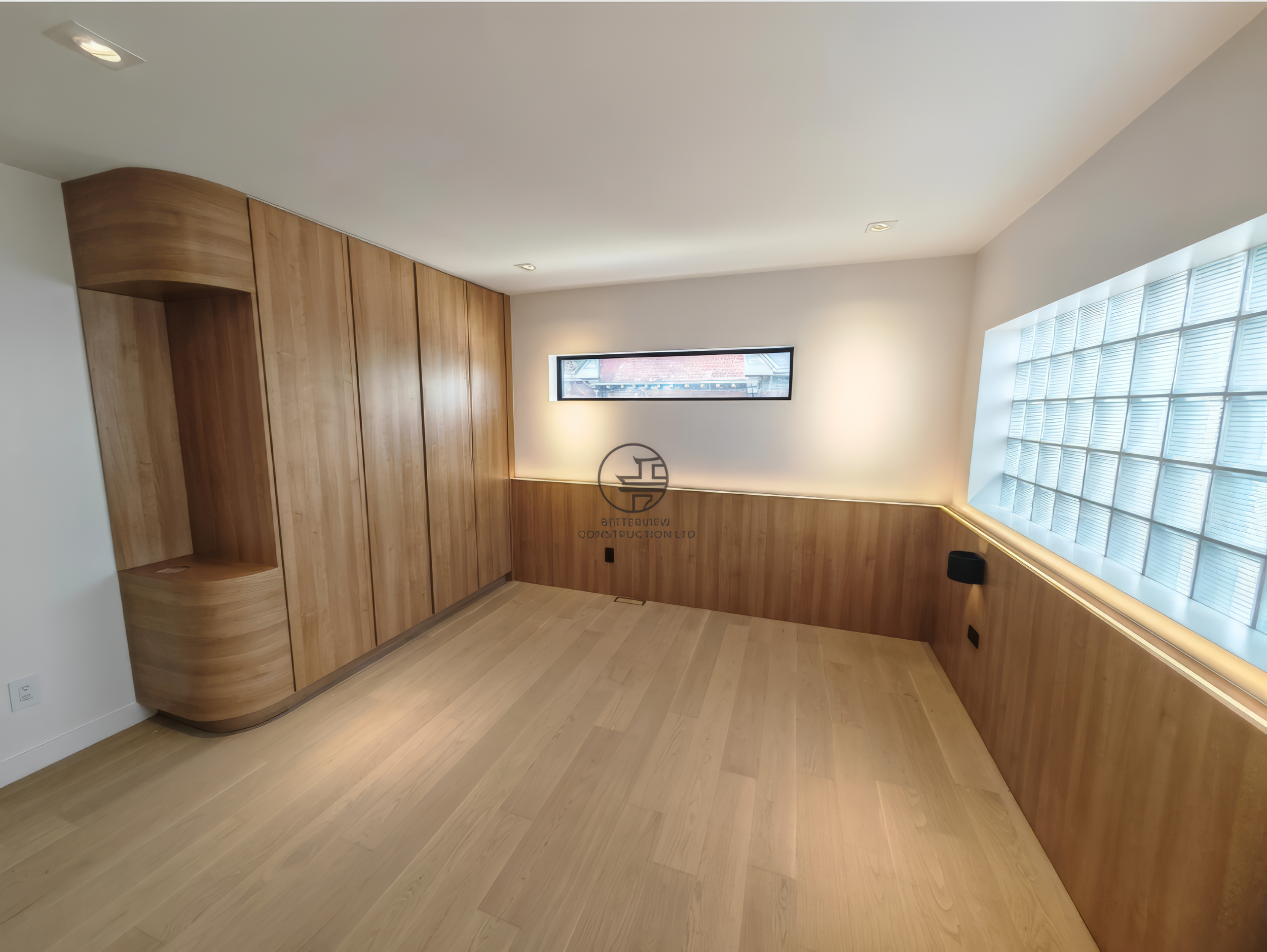 modern basement renovation with custom wood cabinetry, glass block window, and minimalist design