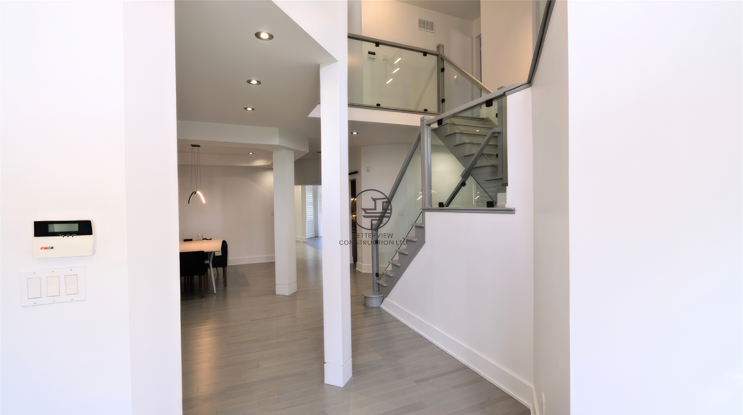 modern home renovation with glass staircase railing and open concept layout