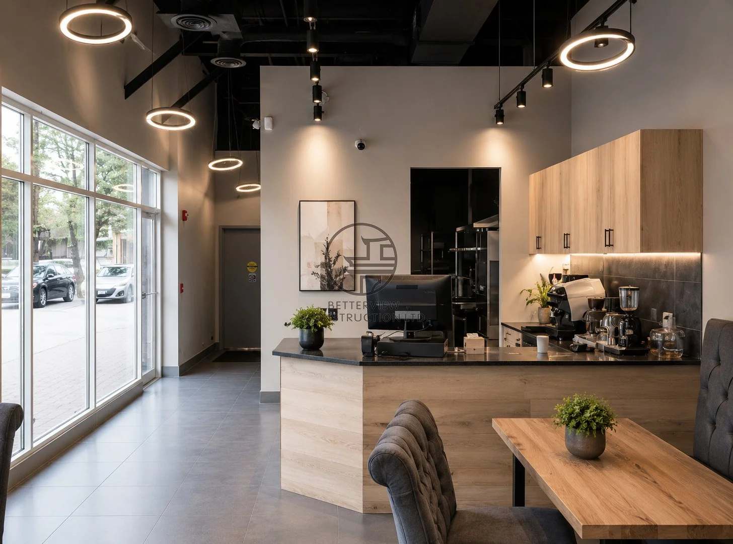 Modern cafe interior renovation in Toronto featuring coffee bar, high ceiling lighting design, and contemporary commercial space