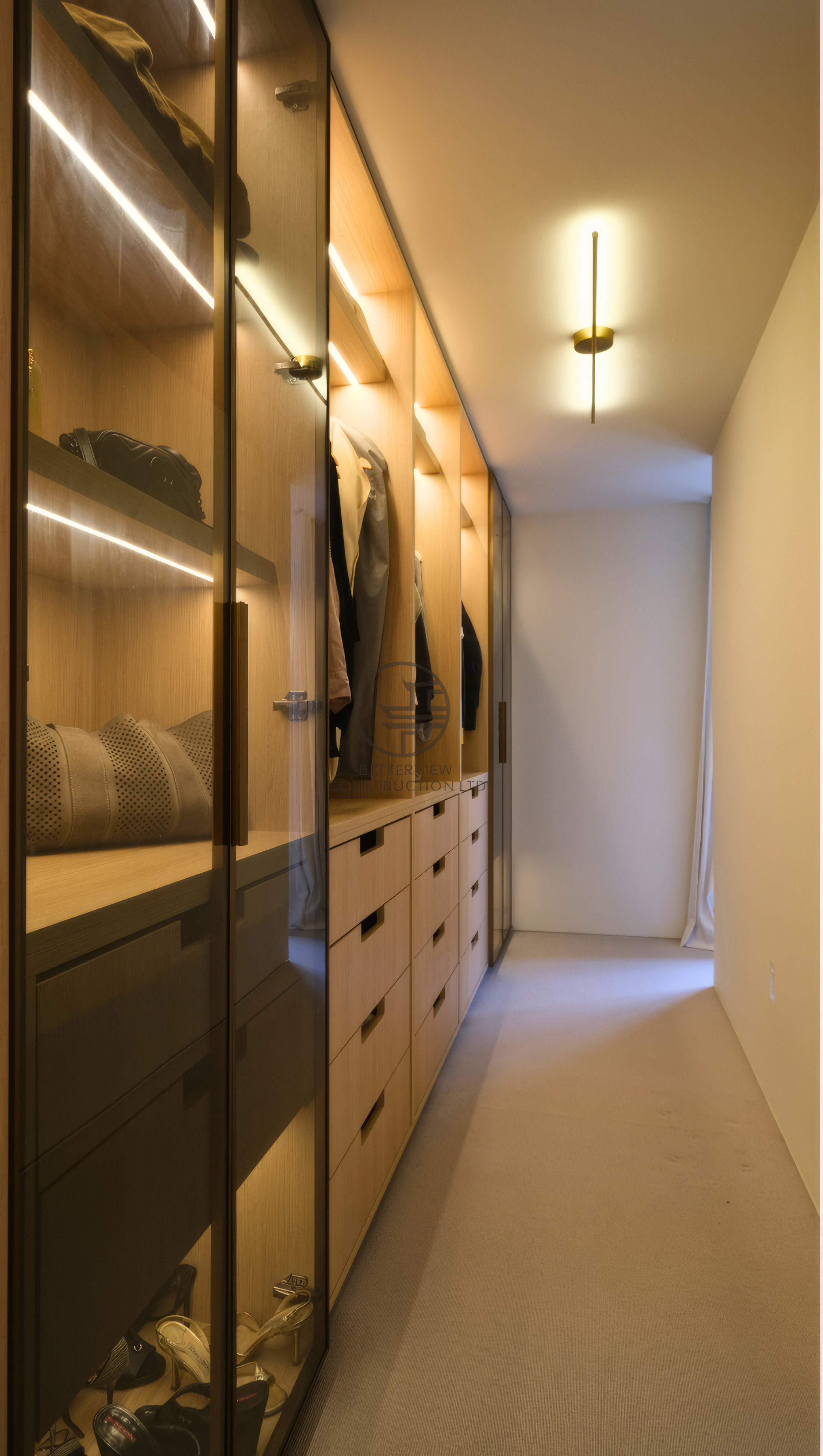 modern walk-in closet with custom wood storage and glass cabinets